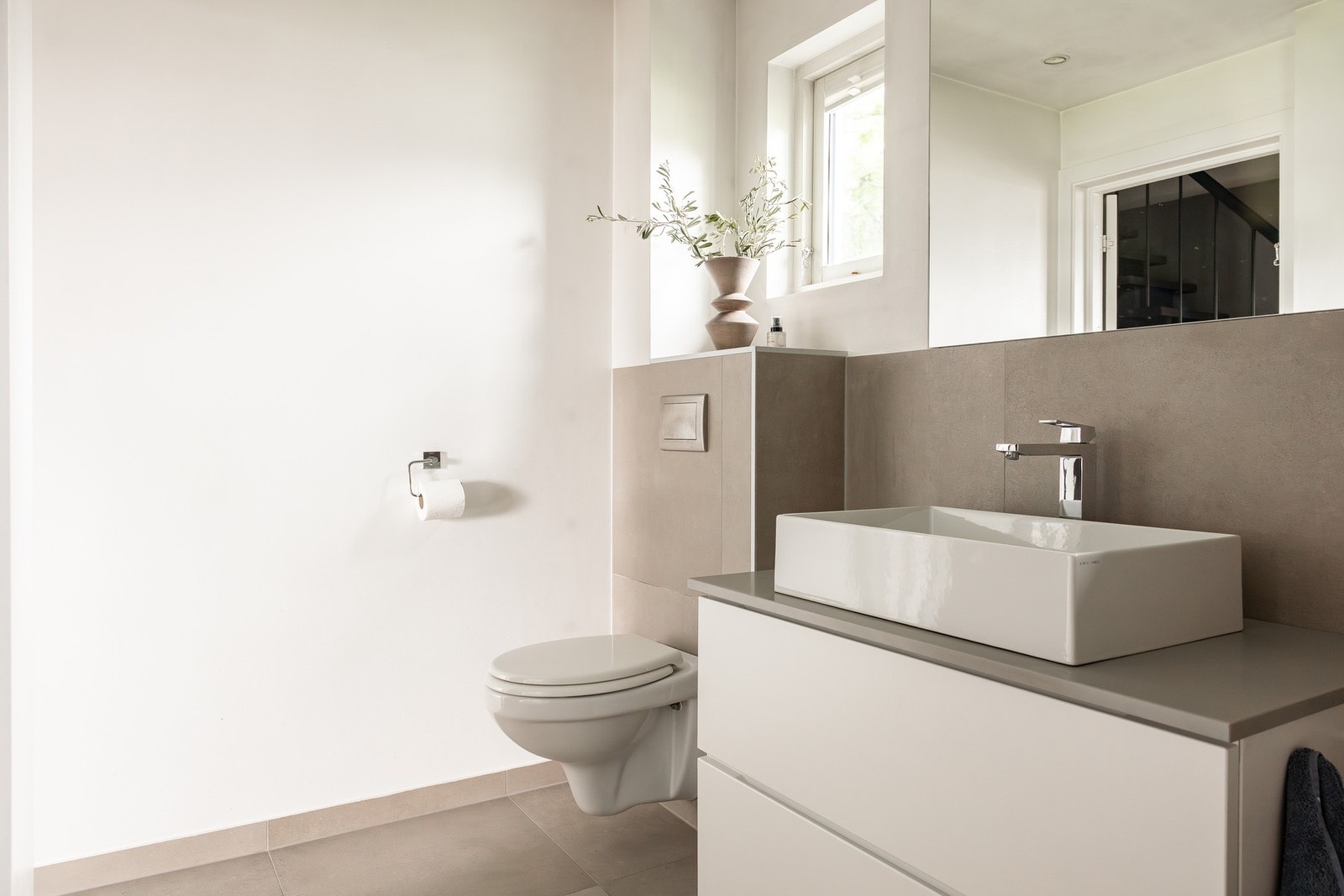 Badet er innredet med en moderne servantinnredning med god oppbevaringsplass, speil med overlys og vegghengt toalett. Galleribilde