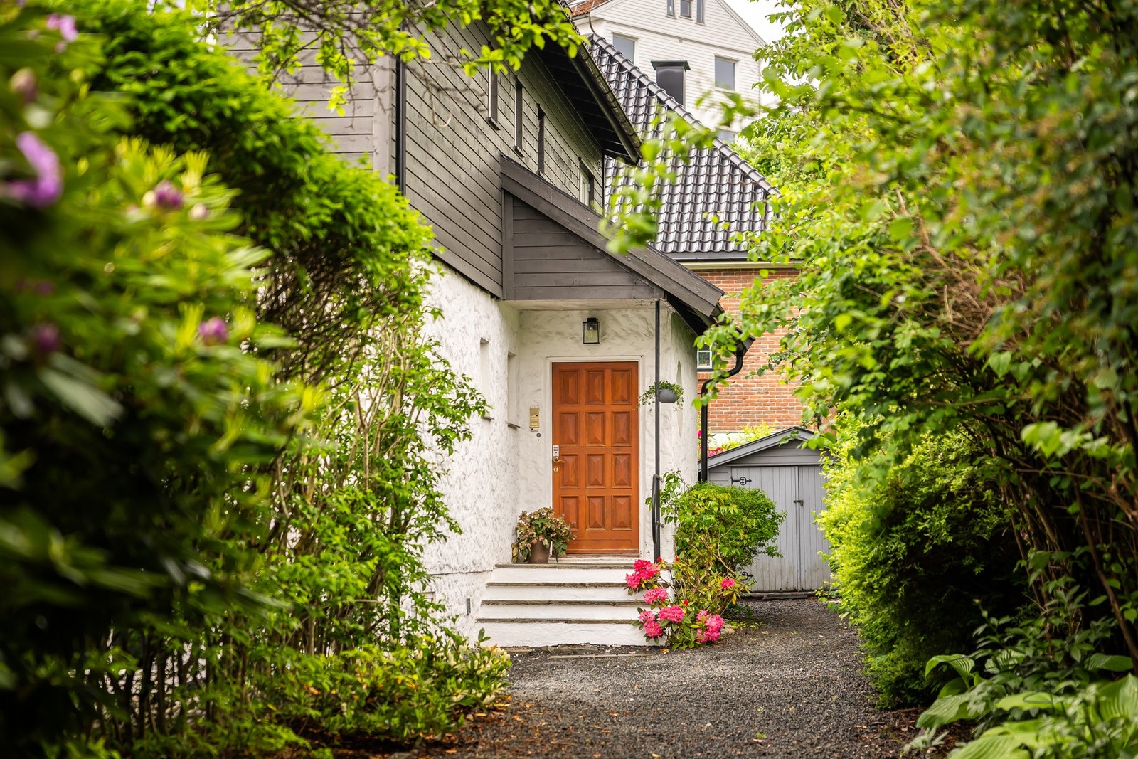 Hyggelig og innbydende inngangsparti omgitt av frodig beplantning som gir en lun og skjermet ankomst til boligen. Galleribilde