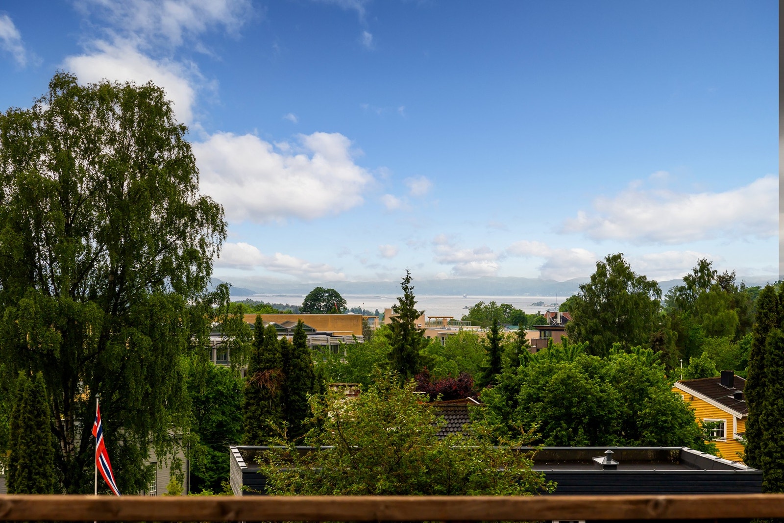 Flott og åpen utsikt mot grønne omgivelser og fjorden i det fjerne, samtidig som plasseringen gir en usjenert og luftig atmosfære. Galleribilde