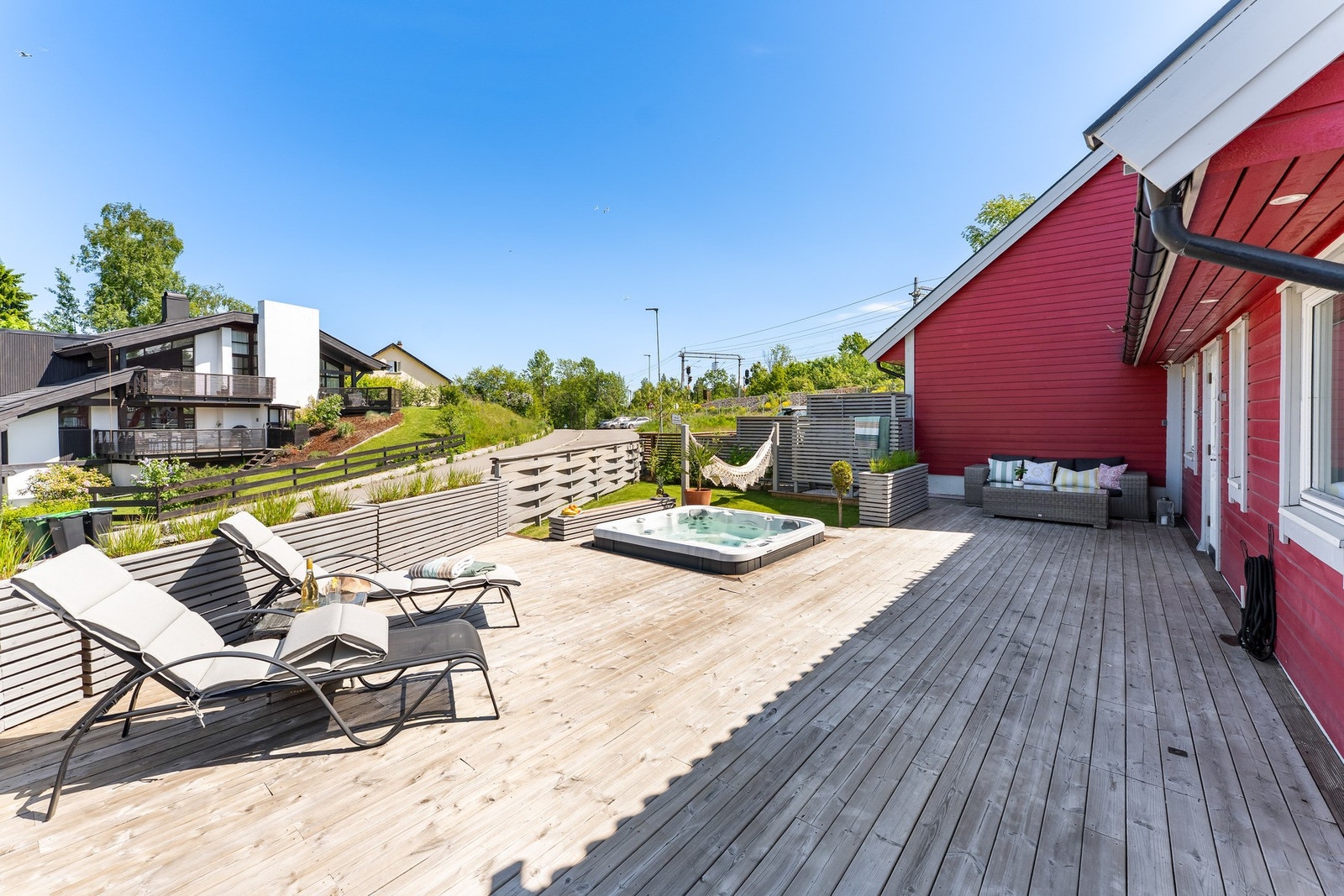 Terrassen strekker seg langs store deler av boligen og har gode solforhold gjennom dagen. Solseil bidrar til behagelig skygge på varme sommerdager. Det er i tillegg utedusj på terrassen. Galleribilde