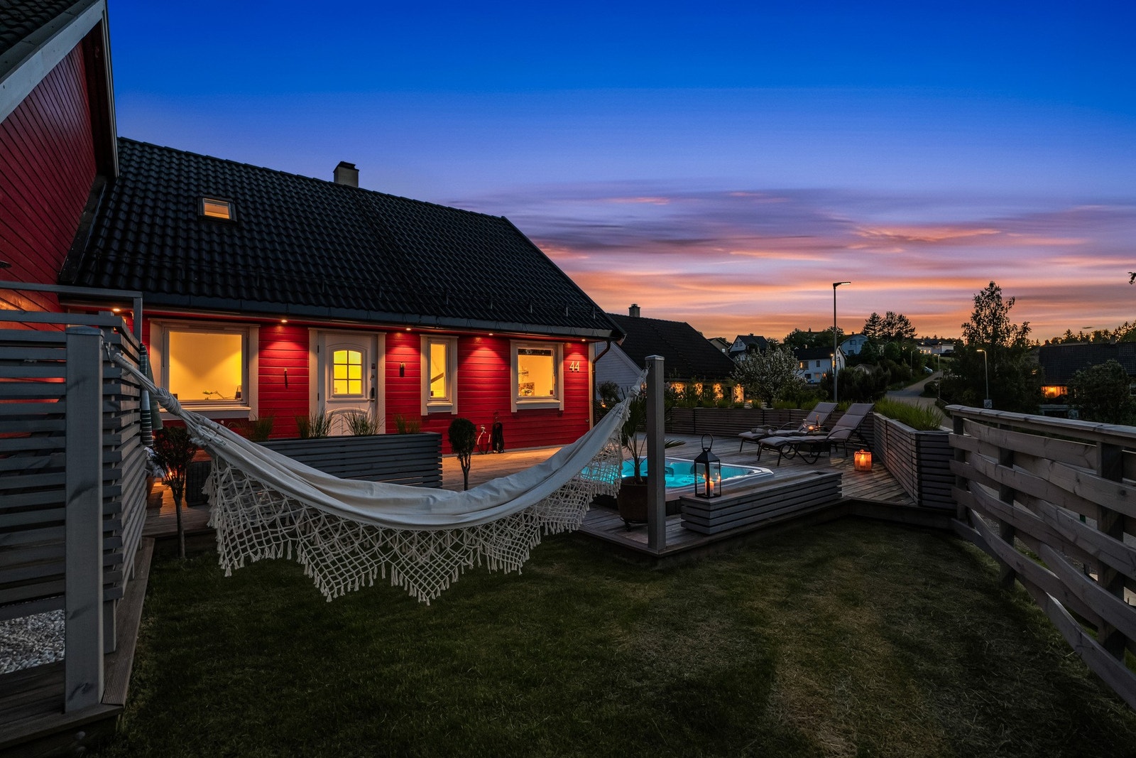 Uteområdet er pent opparbeidet med terrasse, gressplen og skjermede sitteplasser. Jacuzzi gir eiendommen et ekstra element av komfort og trivsel. Galleribilde