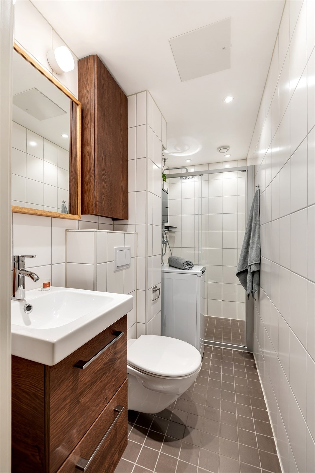 Leiligheten har et lyst og moderne flislagt bad som ble oppgradert av fagfolk i 2014. Badet har mørke gulvfliser med gulvvarme, lyse veggfliser og downlights i himlingen som gir et moderne uttrykk. Galleribilde