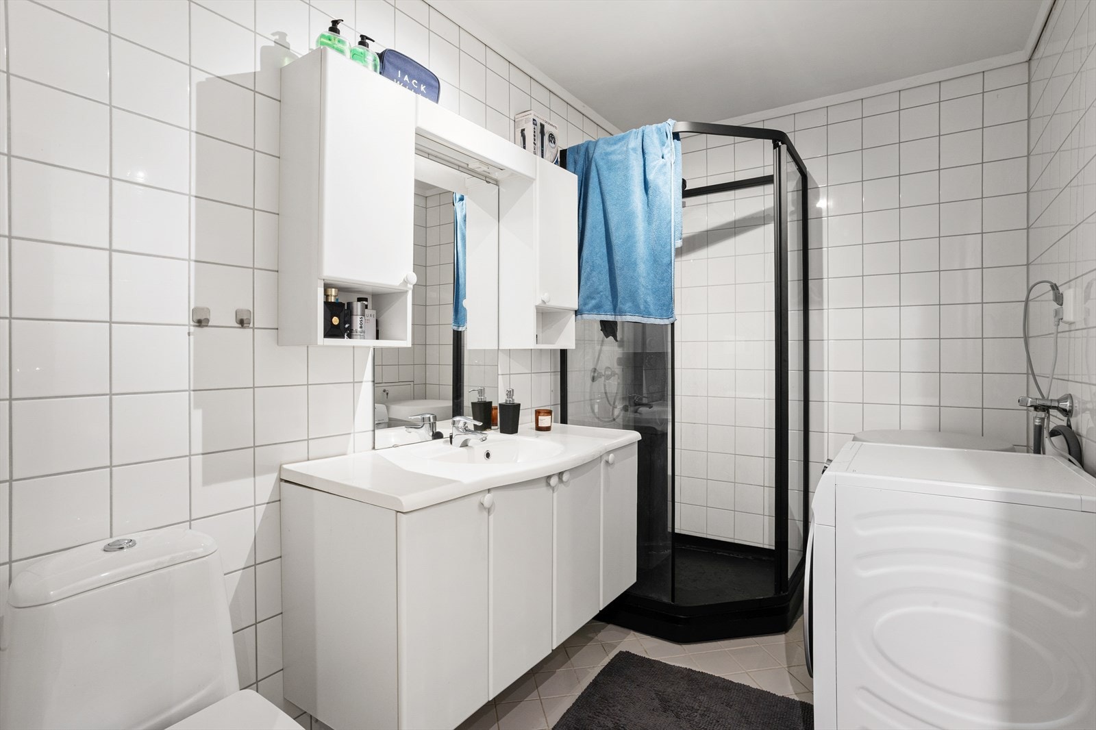 Flislagt bad med elektriske varmekabler i gulvet og opplegg for vaskemaskin. Galleribilde