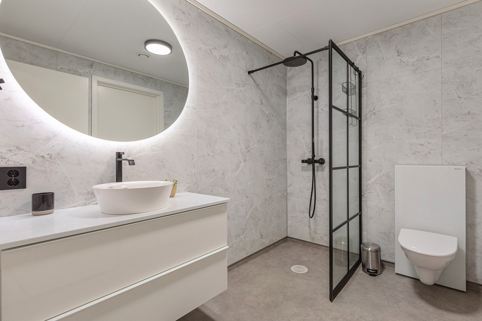 Badet er utstyr med servant, veggmontert toalett og
dusjveggar/hjørne Galleribilde