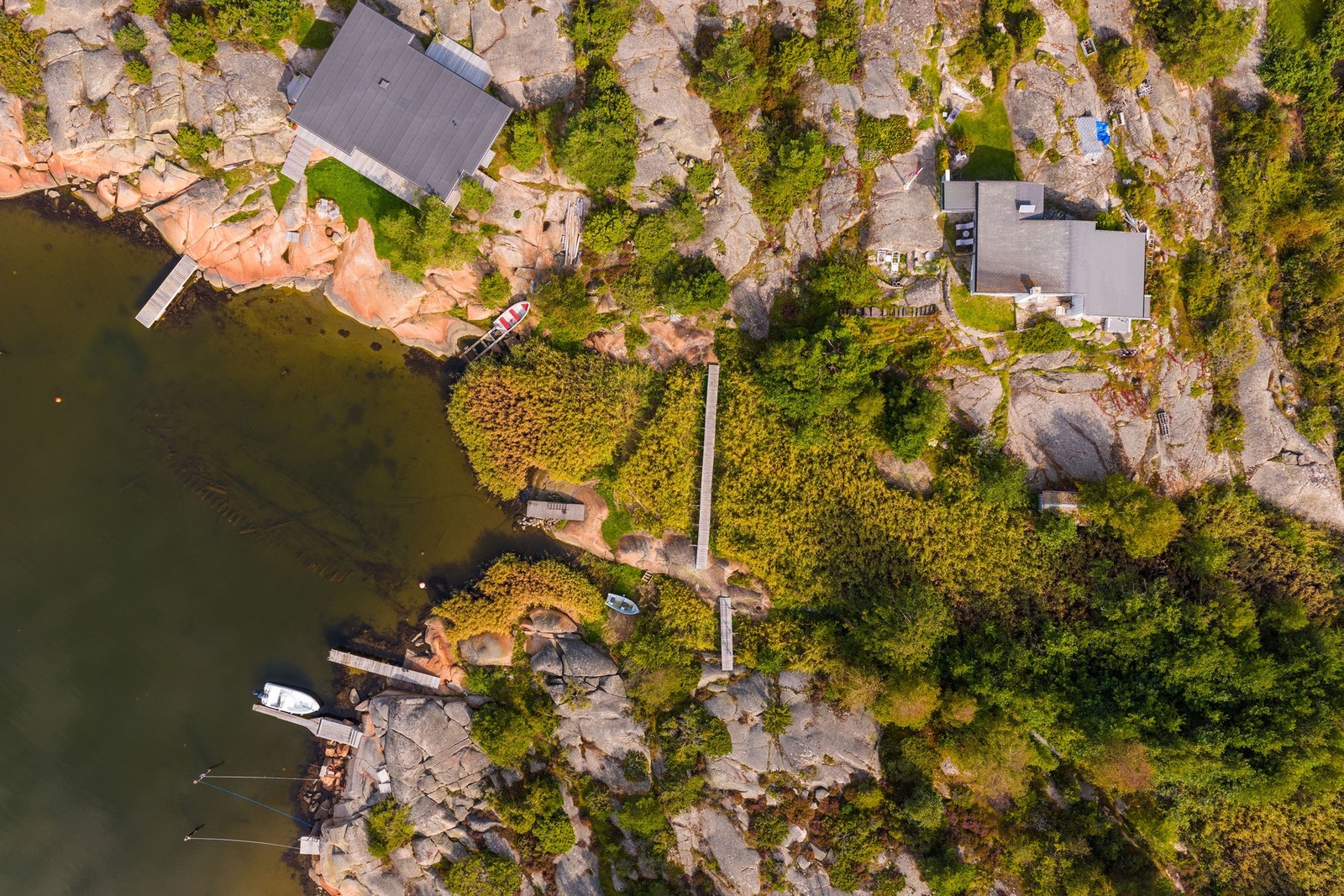 Eiendommen ligger idyllisk til på holme, med gangvei fra vannet eller parkeringsplass på land. Galleribilde
