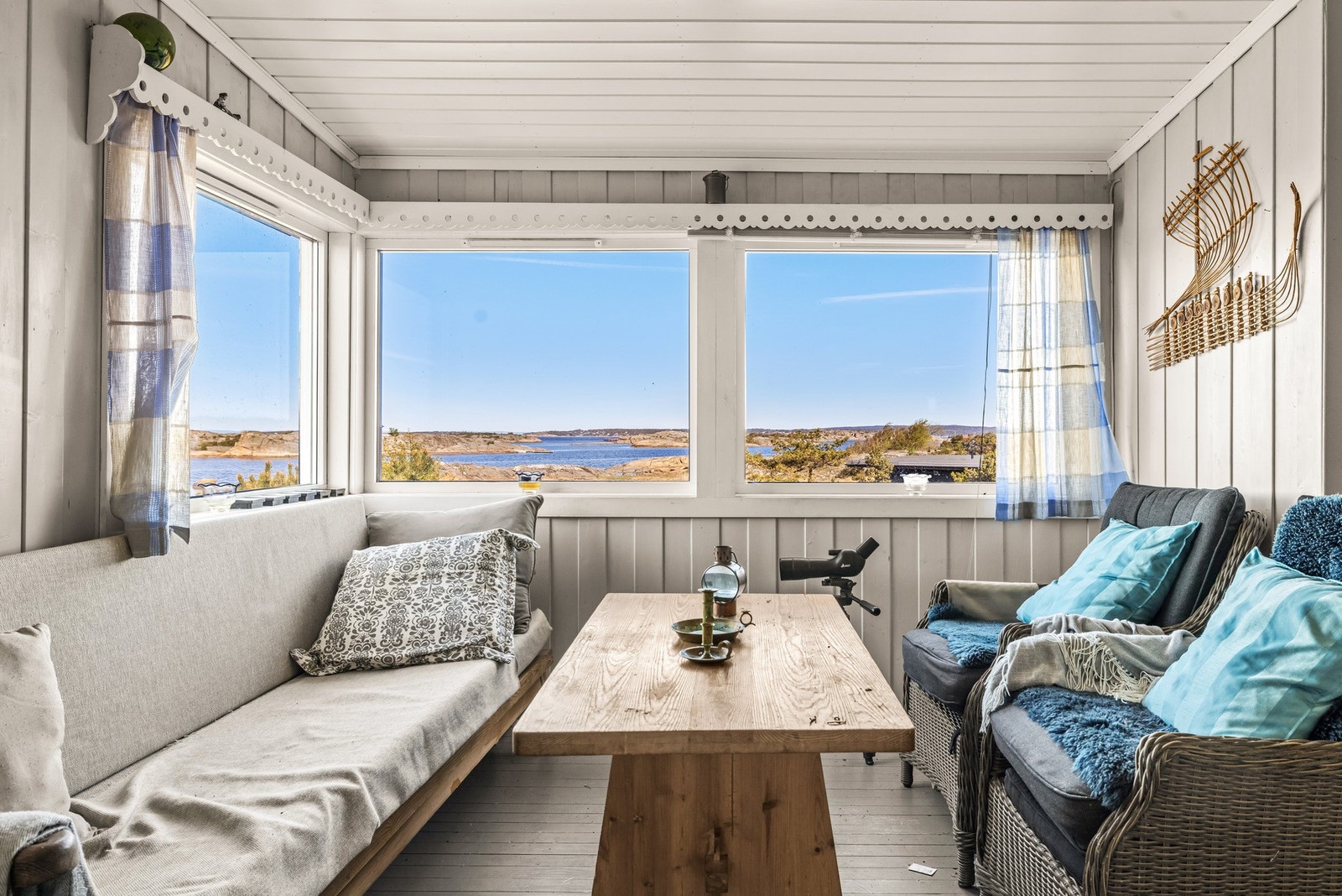 Stue med store vindusflater og panoramapreg mot sjø og skjærgård. Galleribilde