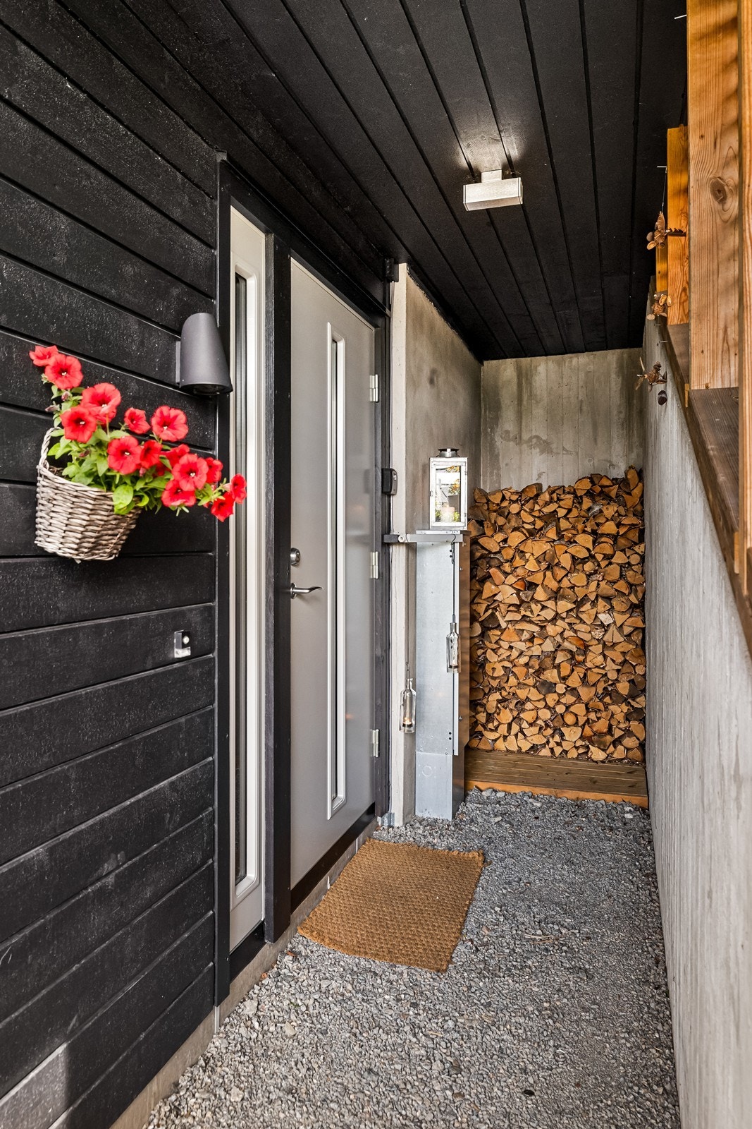 Inngangspartiet er overbygd med belysning og plass til vedoppbevaring. Galleribilde