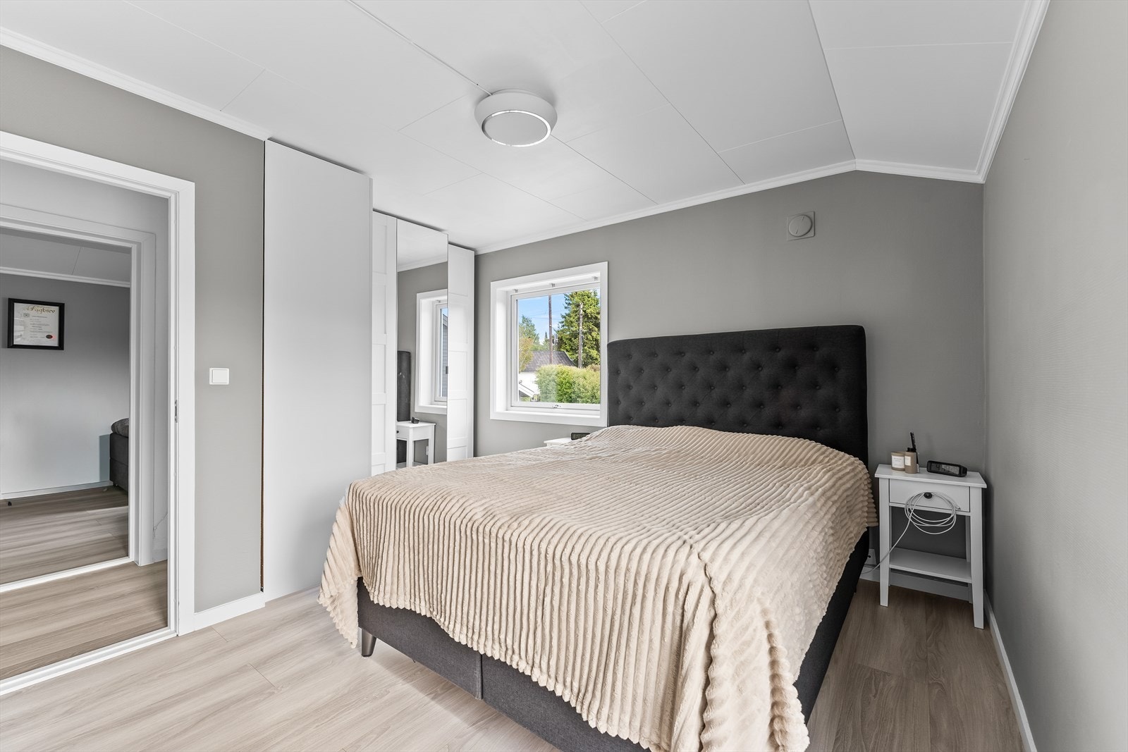 Hovedsoverommet er lyst med plass til dobbeltseng, nattbord og garderobeskap. Galleribilde