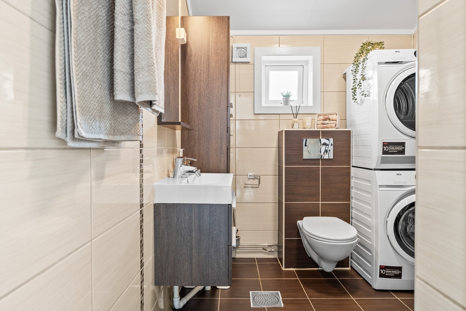 Badet er pent helfliset, har plass til vaskesøyle og varmekabler i gulv. Galleribilde