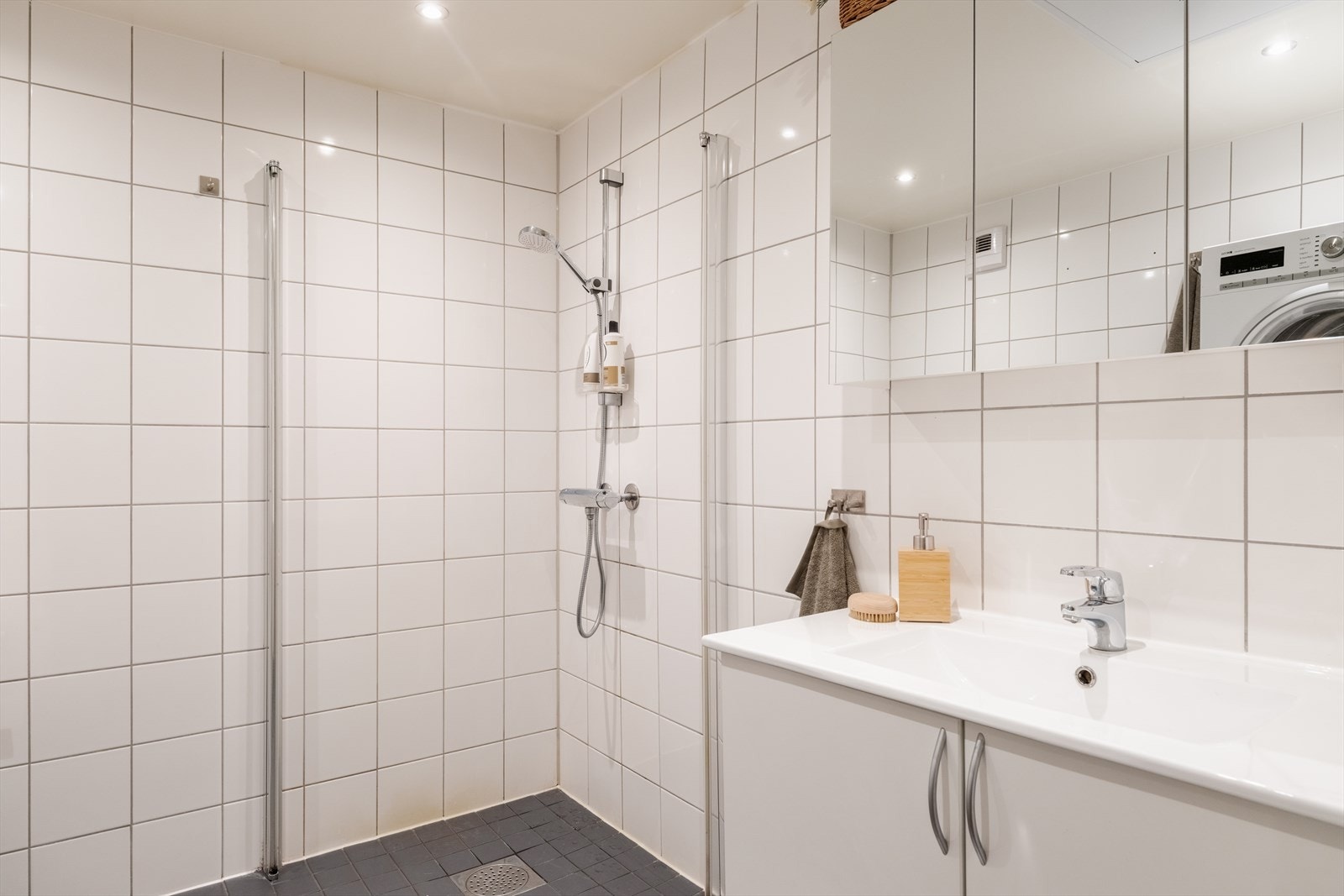Badet består av servant, speilskap, lysarmatur, vegghengt toalett, samt dusjnisje med innfellbare dusjdører (dørene står i boden nede og kan enkelt festes på). Galleribilde