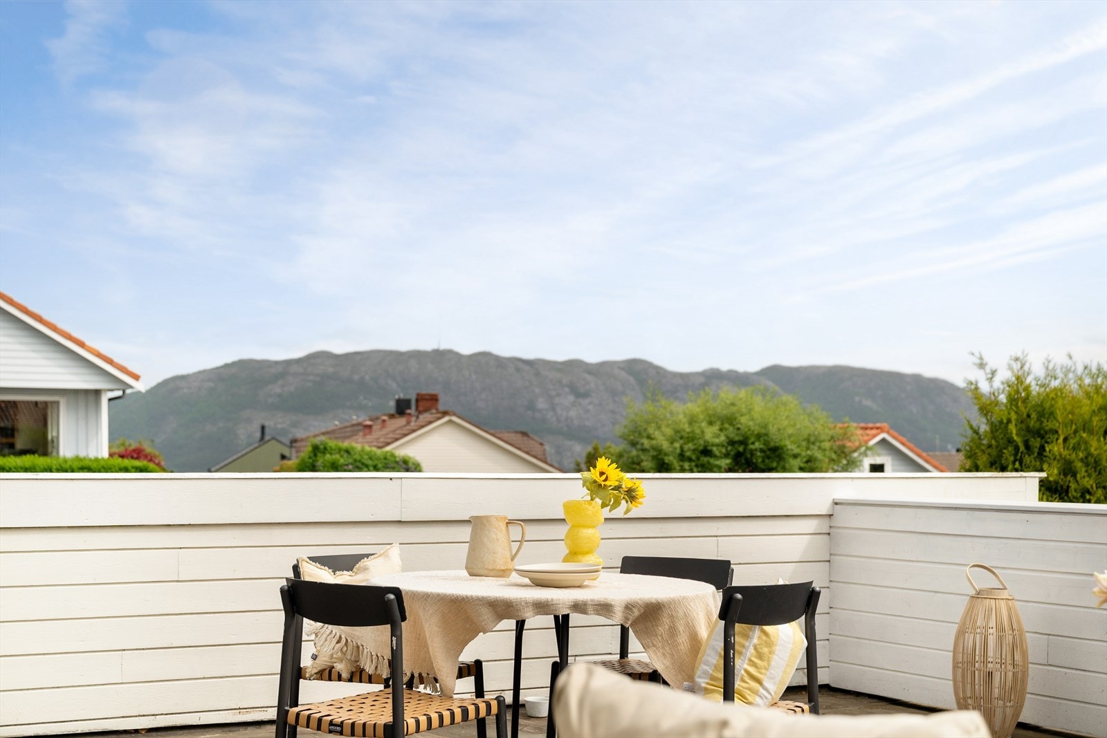 Stor og solrik takterrasse med flott utsikt mot nærområdet og fjellene i bakgrunnen. Galleribilde
