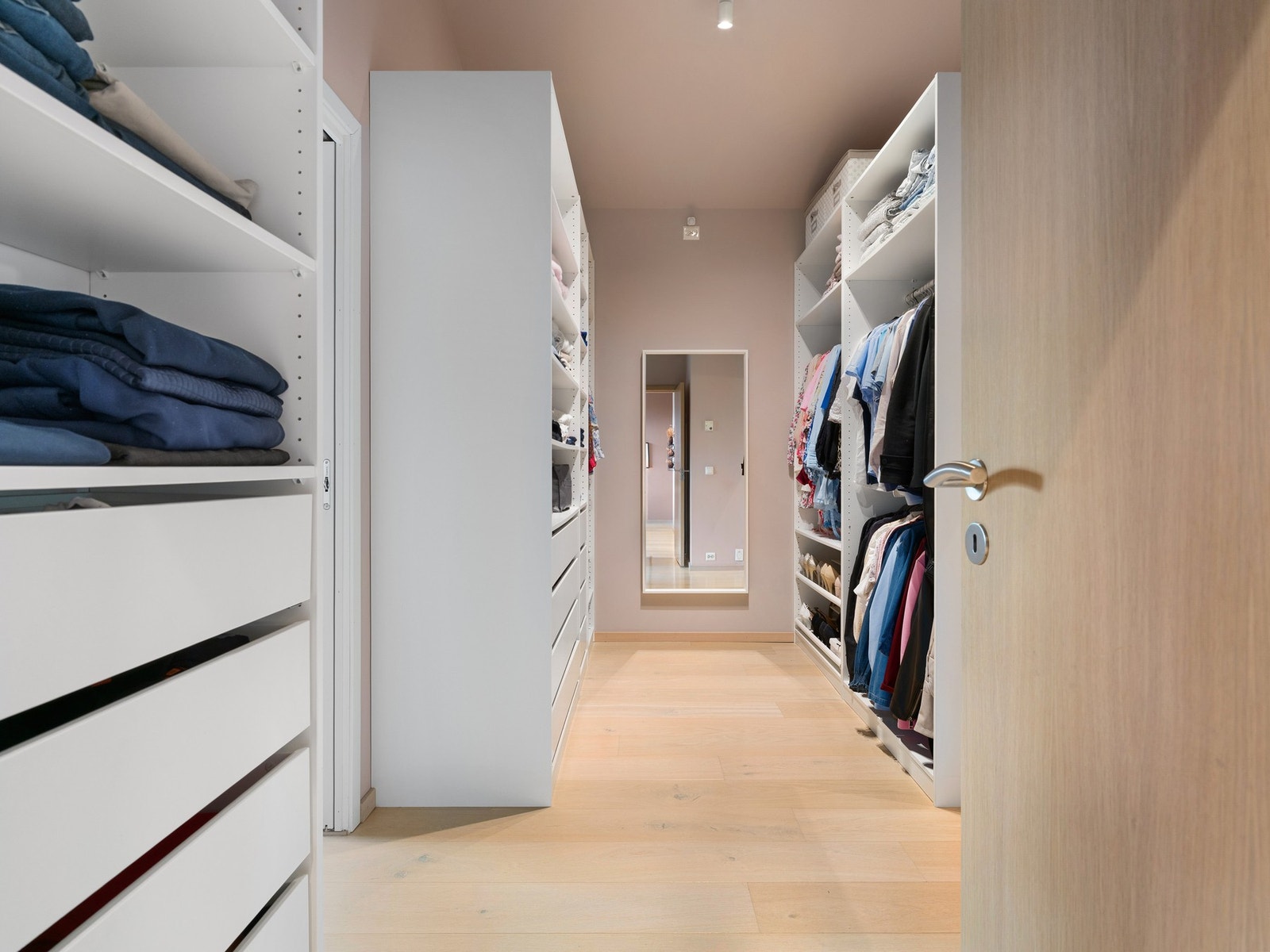 Walk-in closet som ligger i tilknytning til soverommet og gir god plass til organisering av klær og tilbehør. Galleribilde