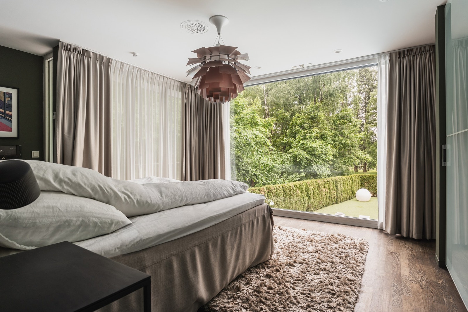 Hovedsoverommet har store vinduer fra gulv til tak og fantastisk utsyn mot hagen og bassenget. Galleribilde