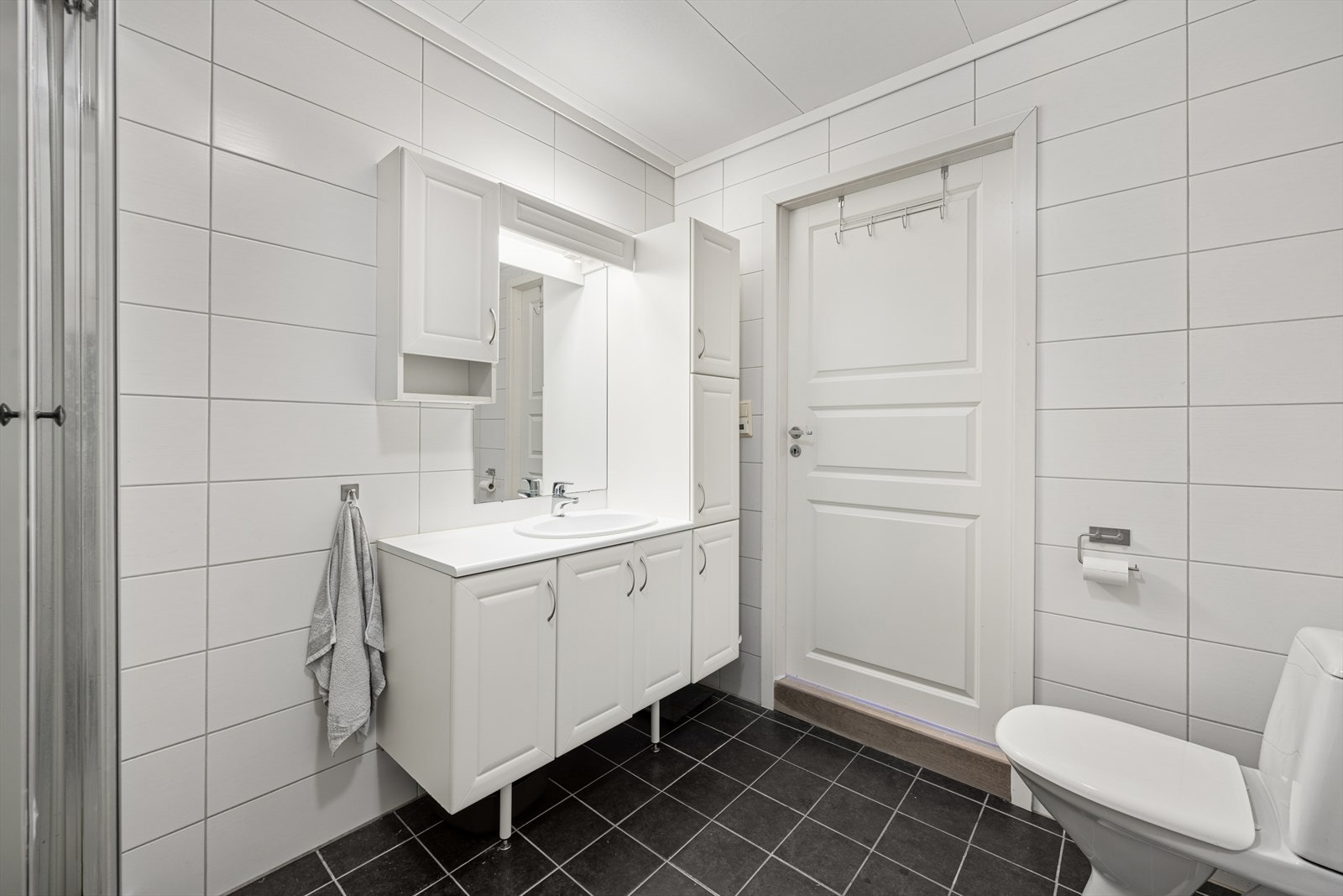 Badet har innredning med nedfelt servant, toalett og dusjkabinett Galleribilde