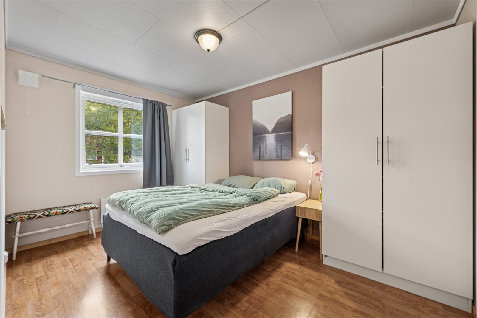 Leilighetens hovedsoverom har god plass til både dobbeltseng og nattbord Galleribilde