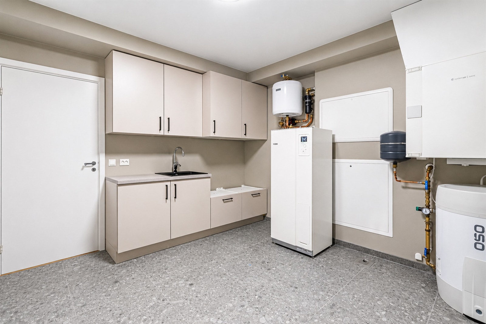 Vaskerom / teknisk rom med innredning fra KEO. Her ligger det balanserte ventilasjonsanlegget, systemet for den vannbårne varmen m.m. Galleribilde