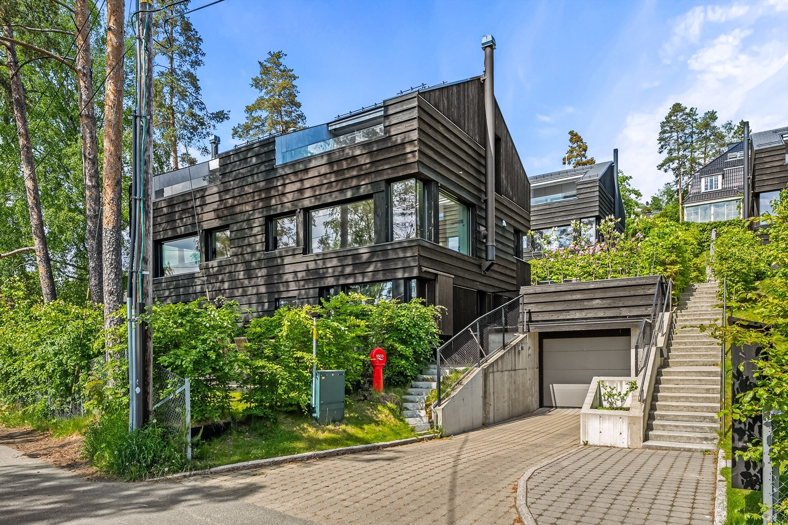 Ved siden av huset er det innkjøring til underjordisk garasjeanlegg, her har du to plasser og elbillader. Galleribilde