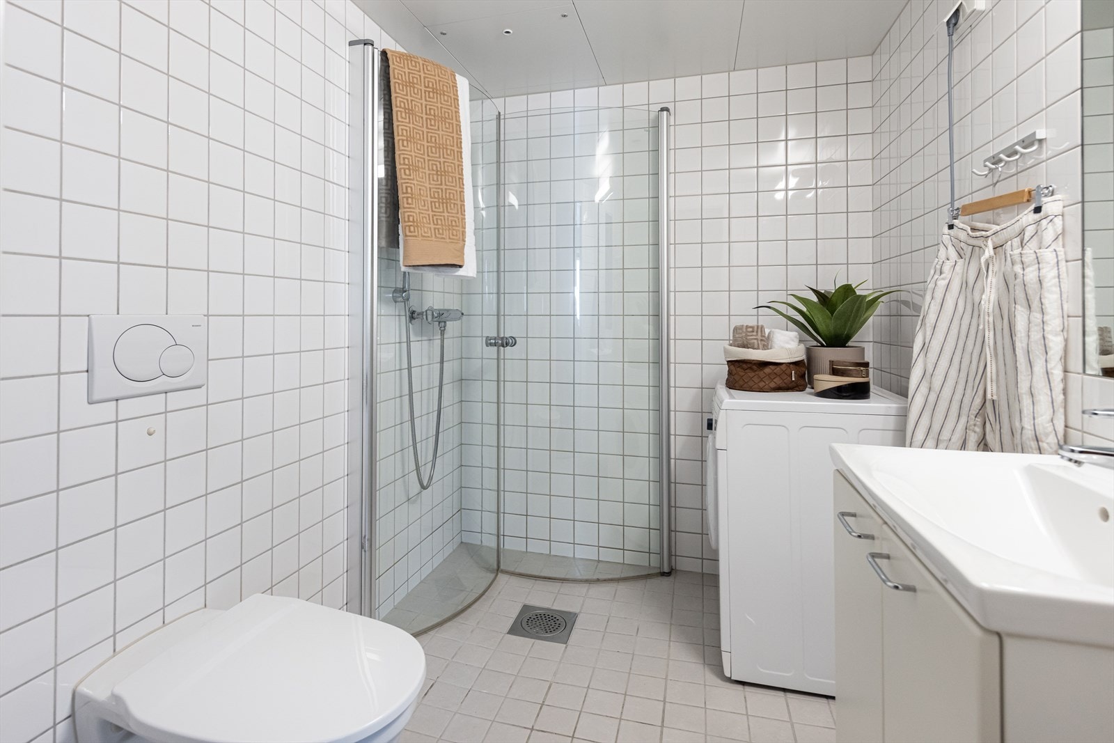 Helfliset baderom med varme i gulvet og opplegg for vaskemaskin. Galleribilde