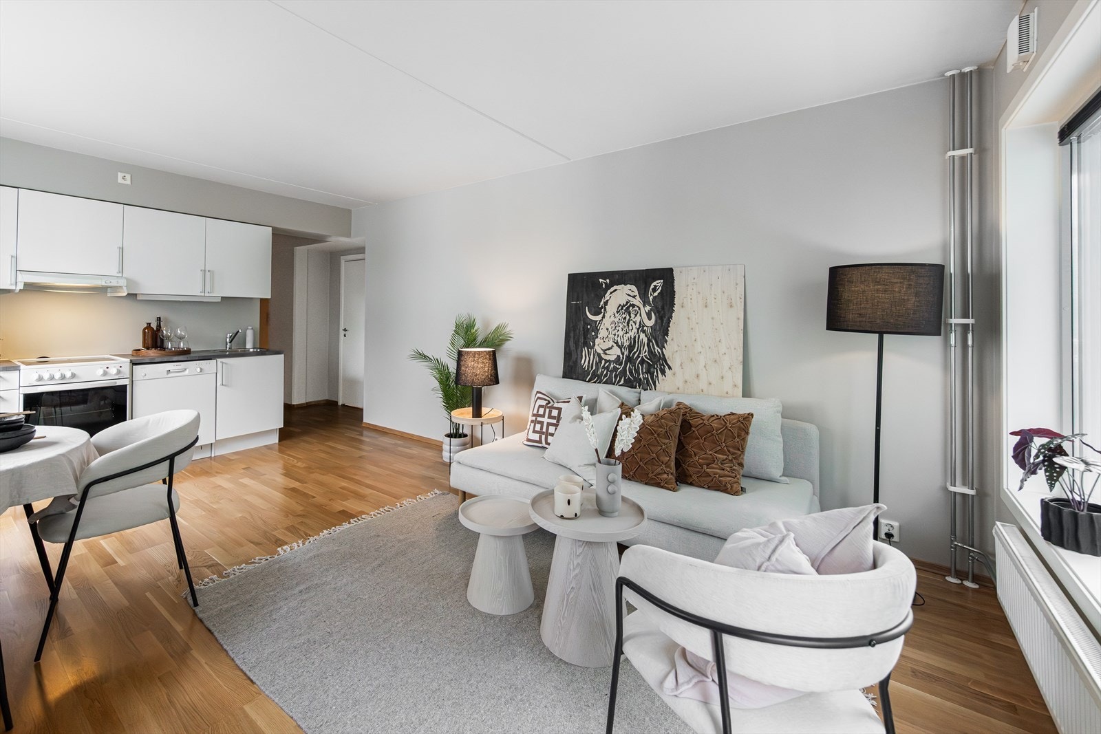 Rommet har parkettgulv, lysmalte overflater fra 2026 og plass til både spisebord og sofagruppe. Galleribilde