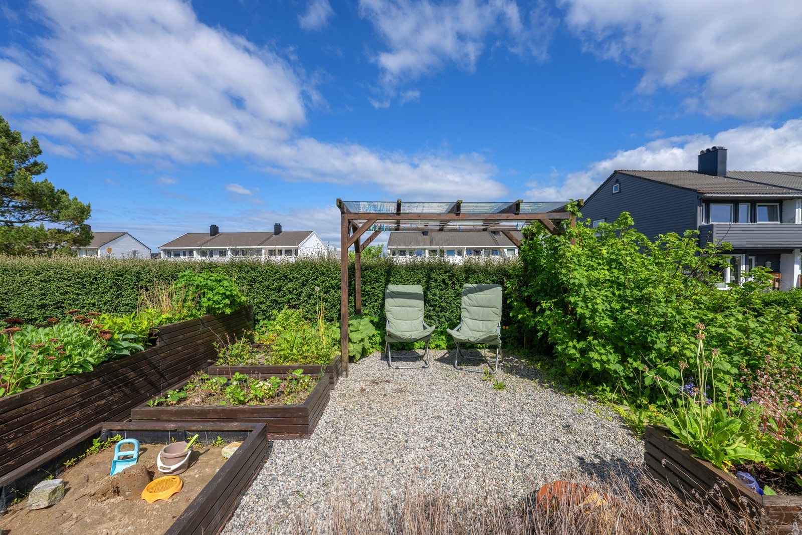 På baksiden av huset er det en pergola, plantekasse og sandkasse. Galleribilde