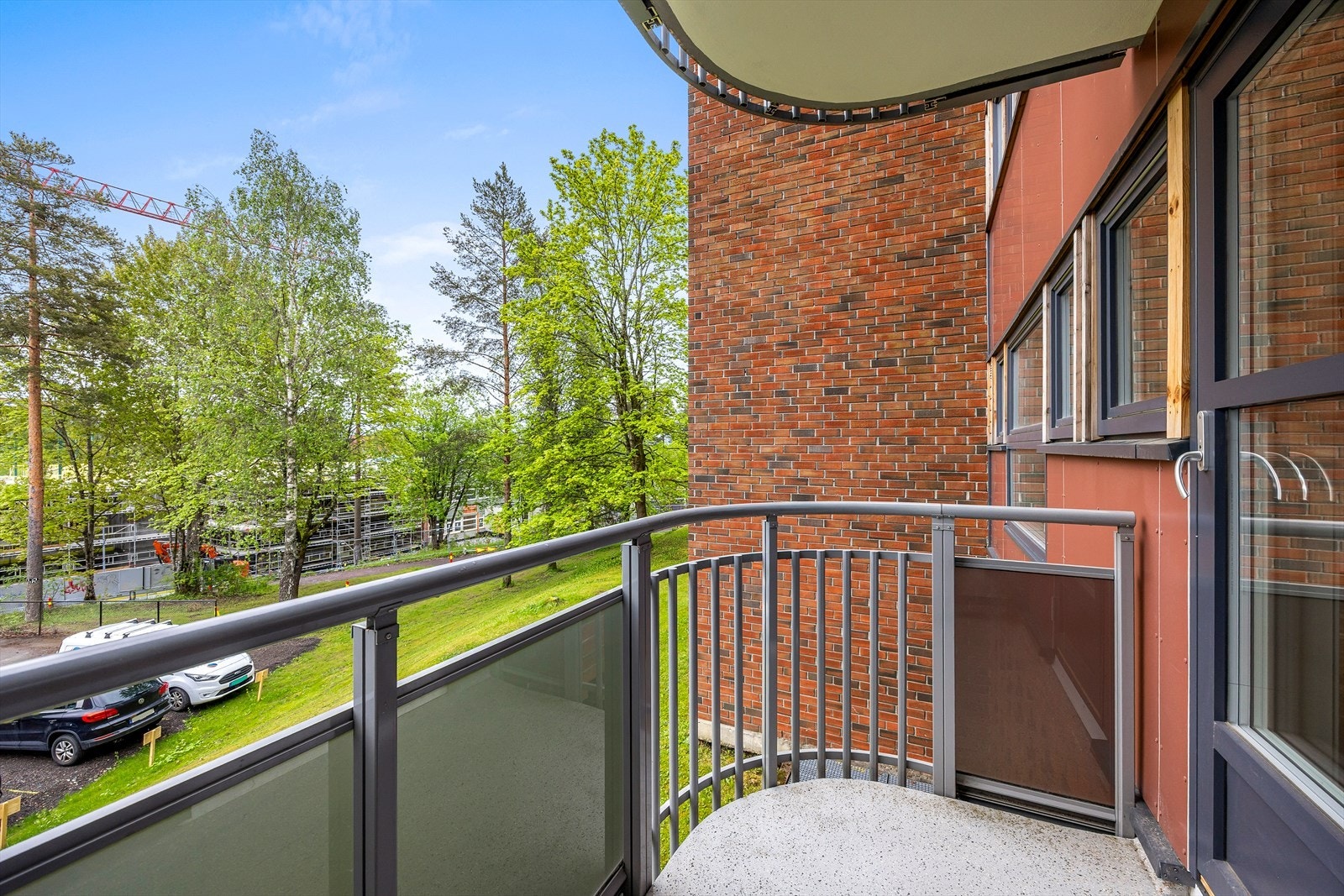 Fra balkongen ser du ut over rolige, grønne fellesarealer. Galleribilde