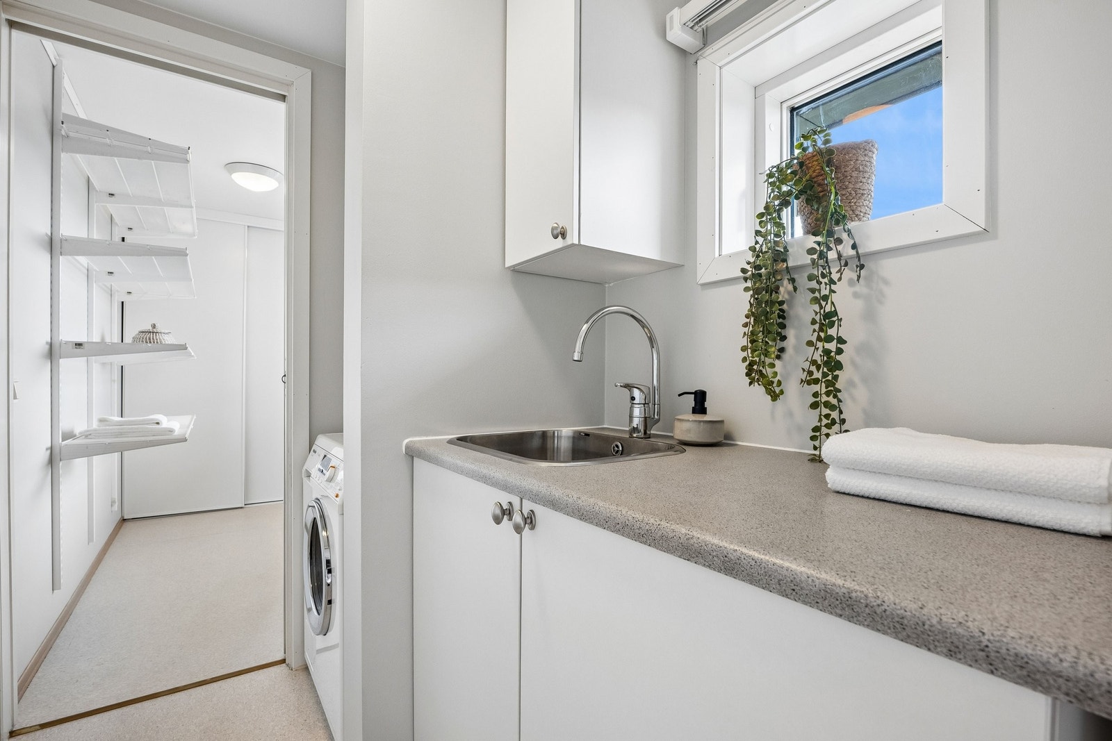 Vaskerom, her det plass til både vaskemaskin og tørketrommel. Det er en romslig skyllekum og skap for oppbevaring. Varmtvannsbereder er også plassert i skap her. Vaske rommet er adskilt fra gang og bod med skyvedør i hver ende. Galleribilde