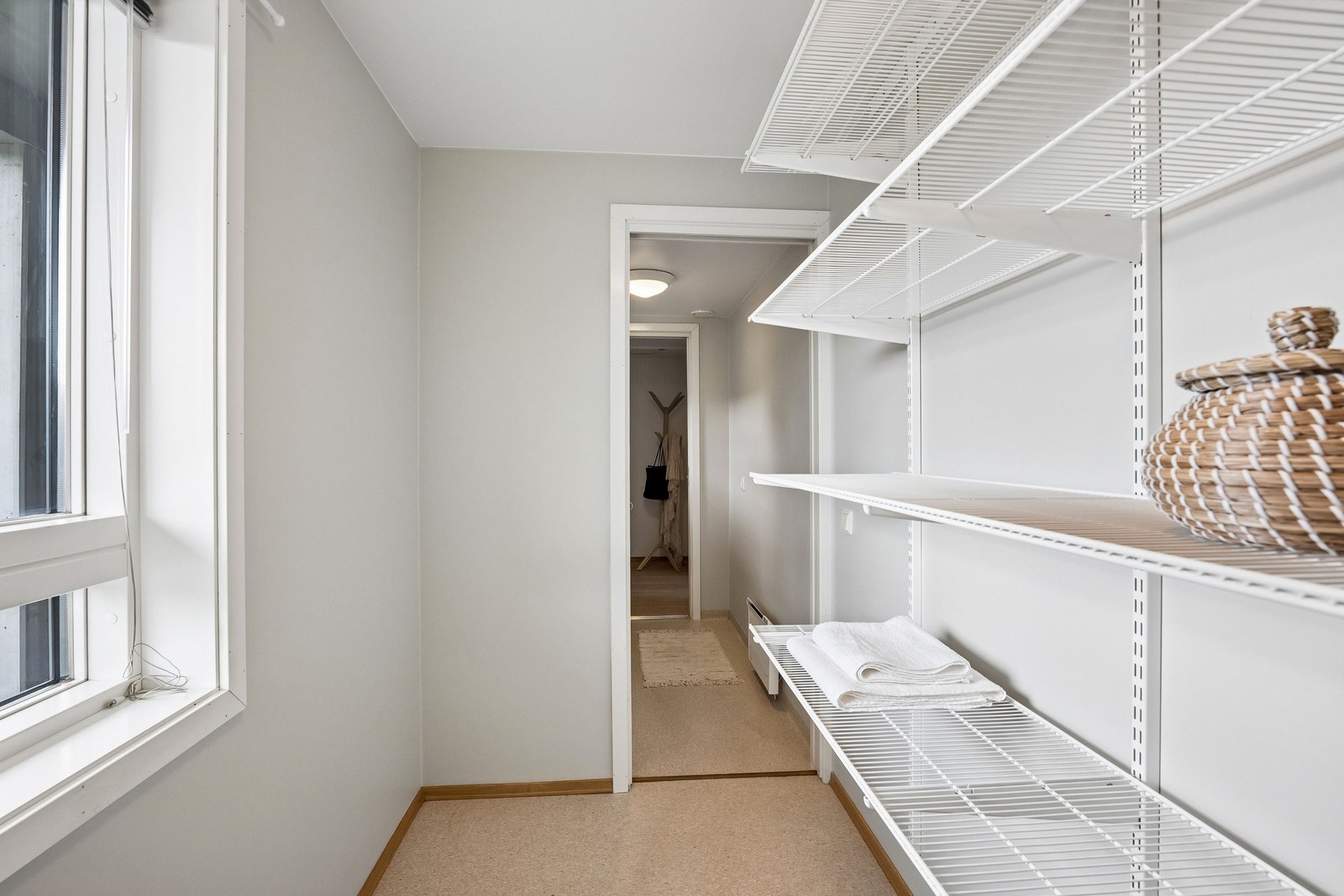 Romslig bod har skyvedørs garderobe med innredning og et solid hylle system fra Elfa for god plass til å lagre og organisere det du trenger. Adskilt fra vaskerom med skyvedør. Galleribilde