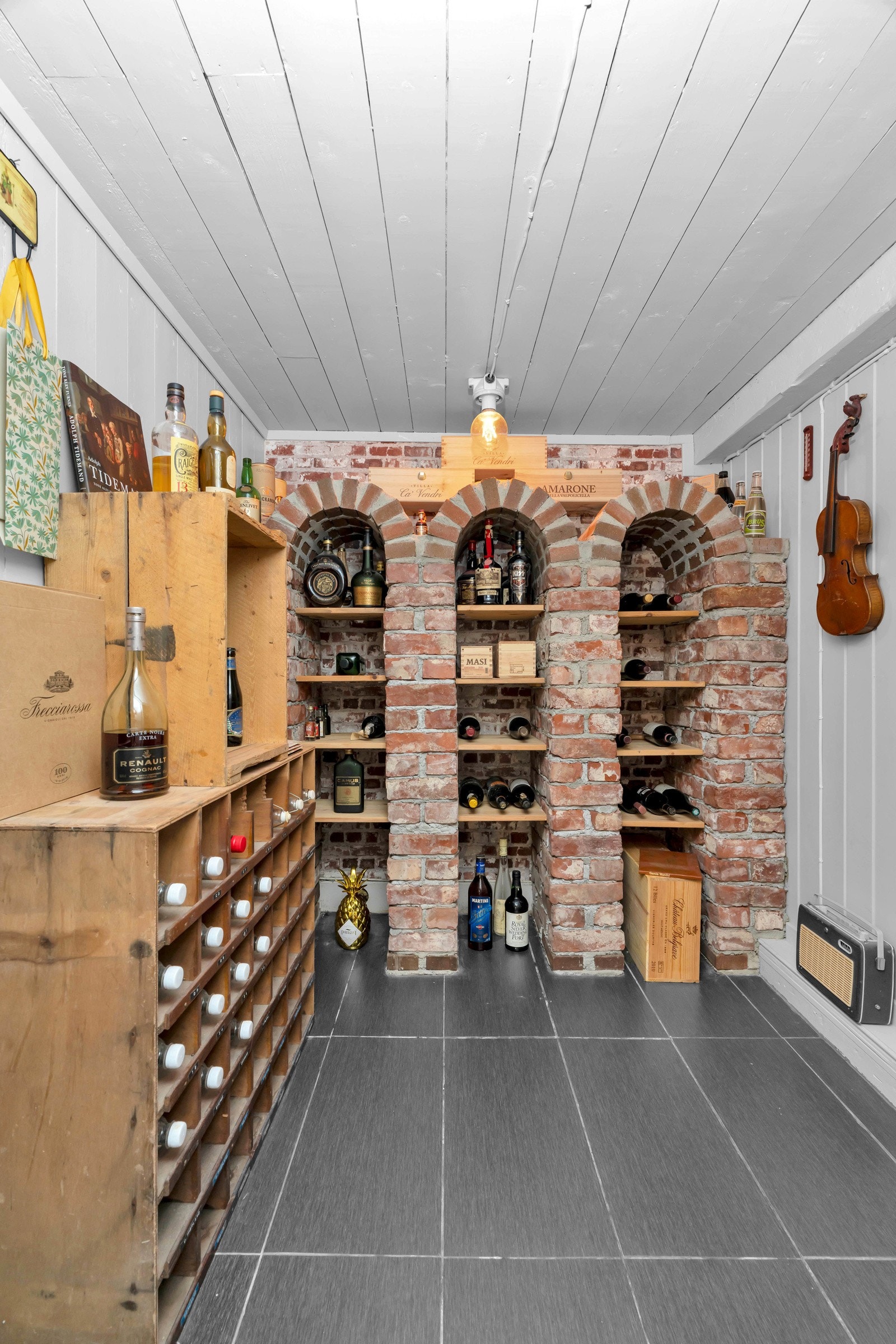 Vinkjeller med fliser på gulv, panel på veggene og murt innredning. Galleribilde