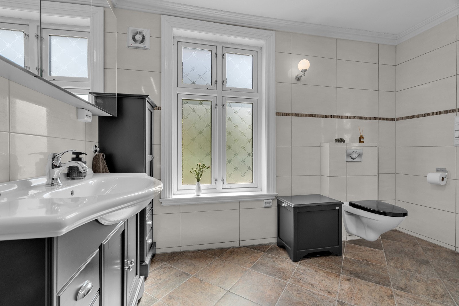 Badet er flislagt med varmekabler i gulv og har innredning fra DuoBad. Badet er oppgradert med speilskap, lys i tak og ny vifte. Galleribilde