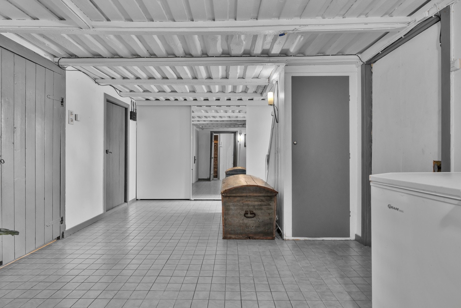 Fra hàllen går det trapp ned til underetasjen som består av romslig gang med varmekabler i gulv, kjellerrom, bod, vinkjeller og vaskerom. Galleribilde