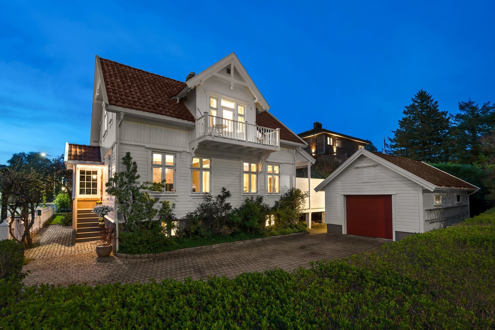 Ærverdig bolig med symmetrisk fasade, nostalgiske detaljer og et flott inngangsparti med belegningsstein, og romslig innkjørsel med garasje. Galleribilde