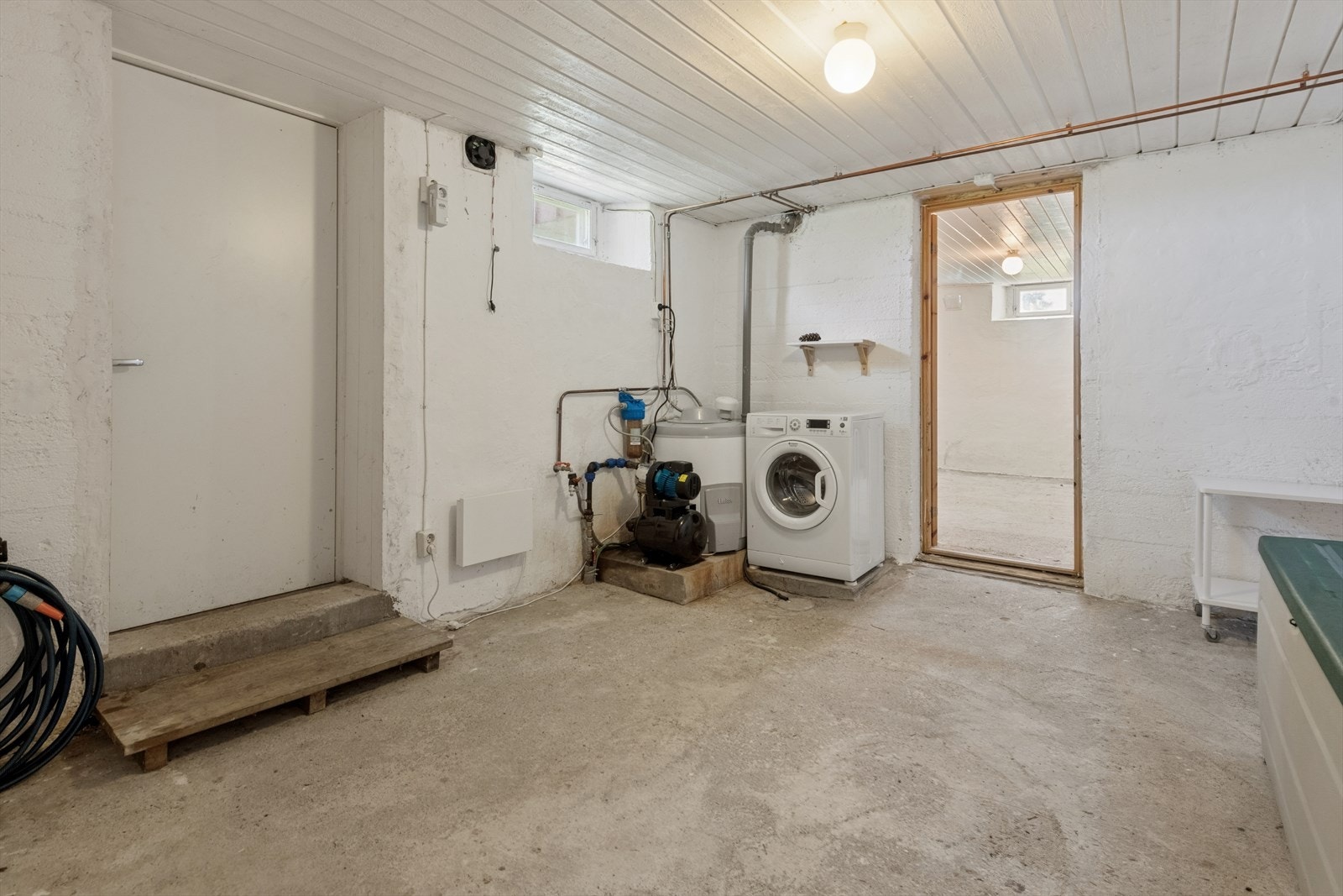 Teknisk rom/vaskerom i kjelleren med opplegg for vaskemaskin og egen utgang. Vaskemaskinen medfølger i handelen. Galleribilde