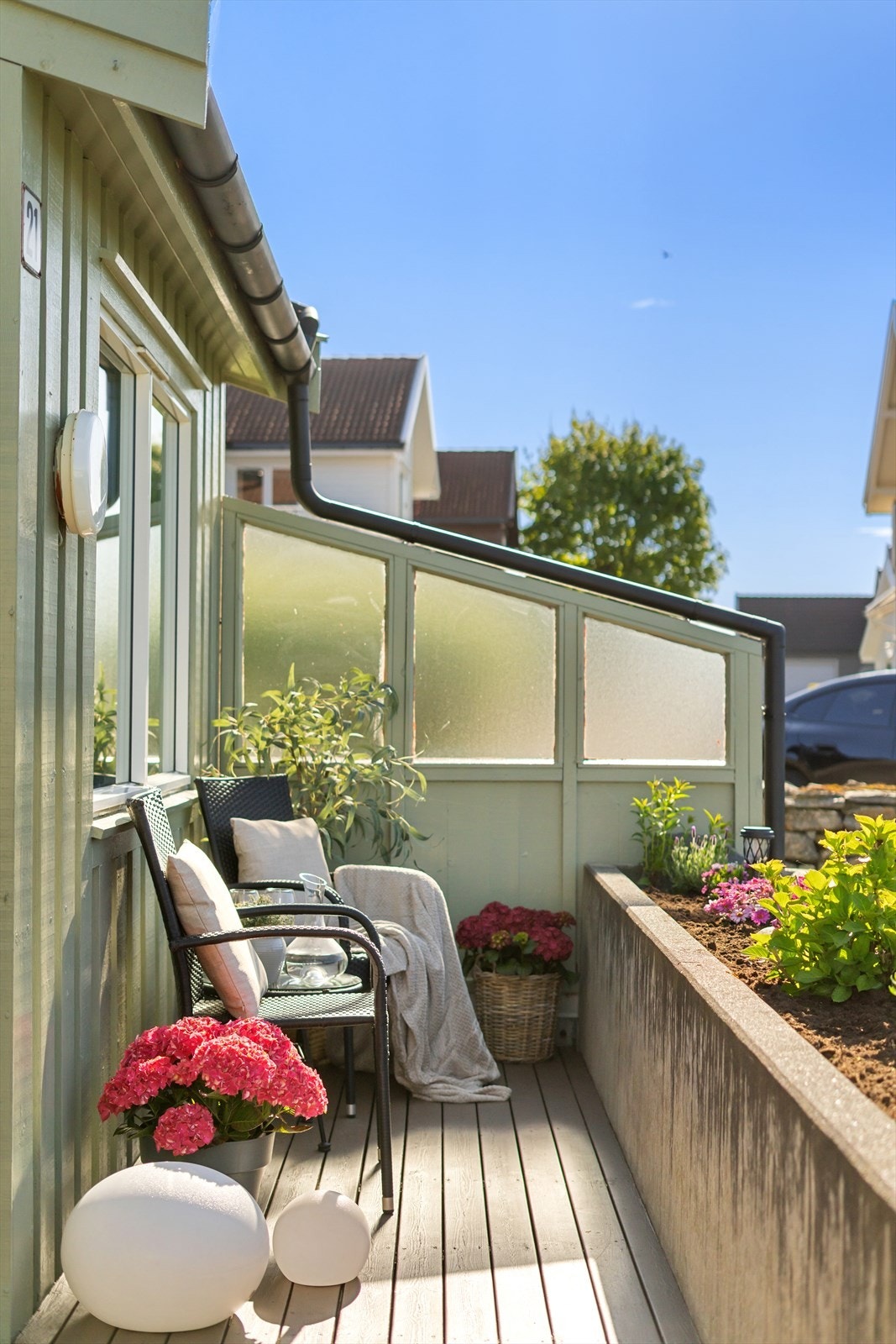 Terrassen har terrassebord og en integrert blomsterkasse i betong som fungerer som rekkverk. Galleribilde