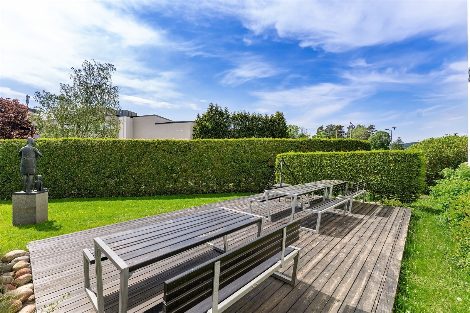 Stor felles sittegruppe på fast terrasse ute på plenen (Østerås senter i bakgrunnen) Galleribilde