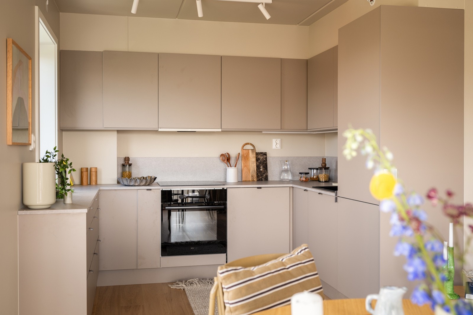 Du har god skap- og benkeplass i innredningen som har glatte fronter i en fin farge og laminert benkeplate med nedfelt servant. Både fint og praktisk med plater i benkeryggen og LED-belysning under overskapene. Galleribilde