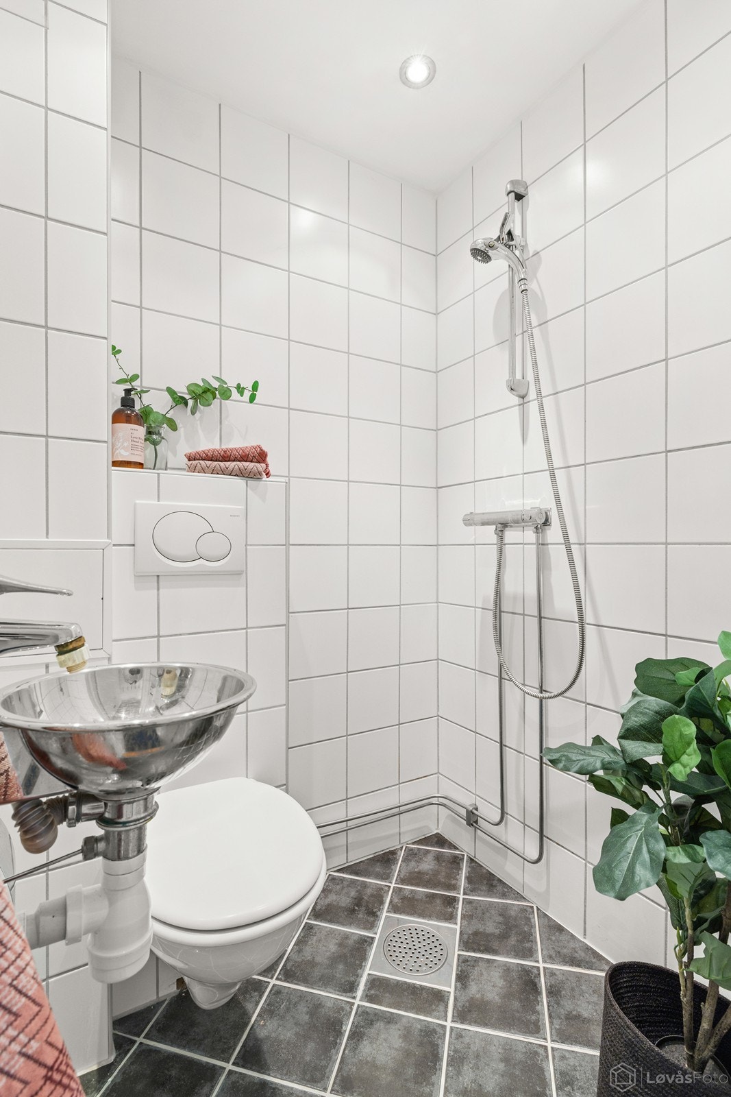 Det flislagte badet er innredet med klosett, servant med overspeil, samt dusjhjørne. Galleribilde