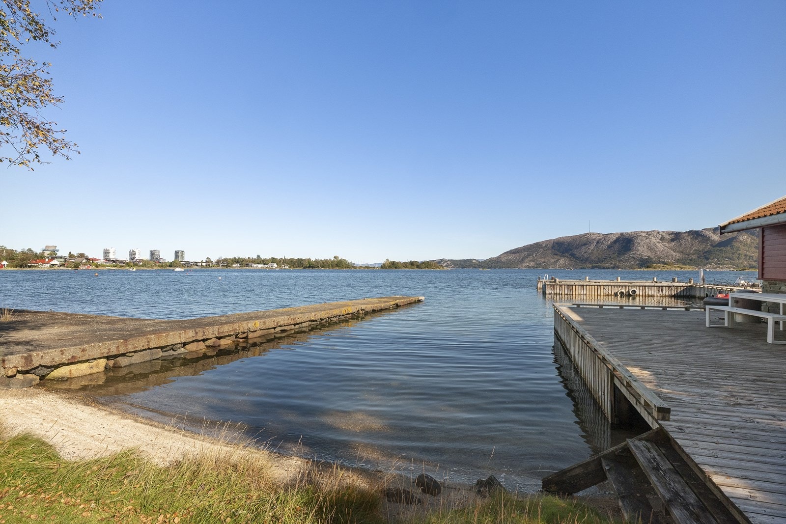 Den private strandlinjen inkluderer en liten sandstrand og et solid brygge Galleribilde
