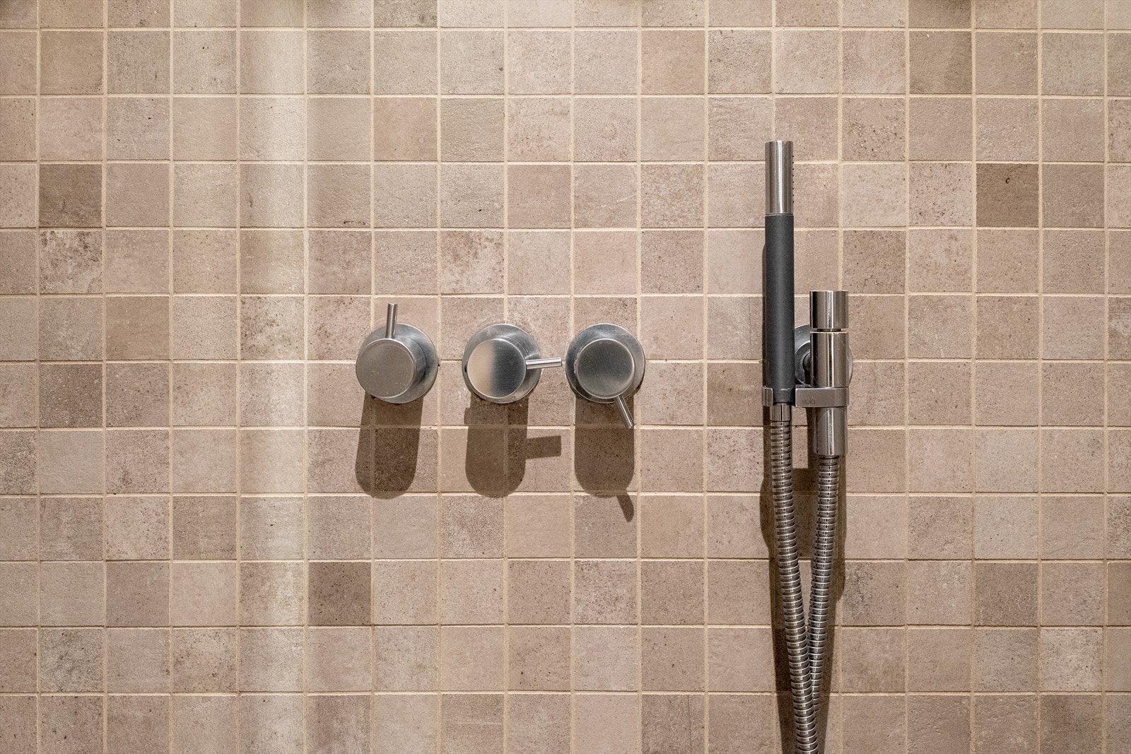 Detalj fra dusjnisjen, som har slukrenne langs veggen for et rent uttrykk. Galleribilde