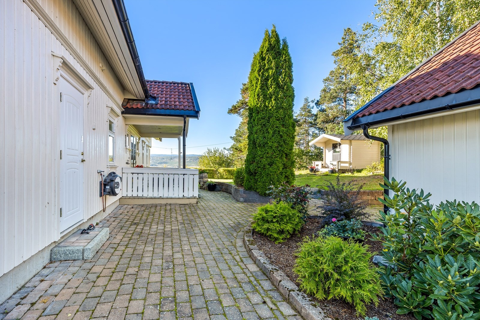 Det er påkostet uteområde med belegningsstein i gårdsplass, ved inngangsparti og rundt boligen. Galleribilde