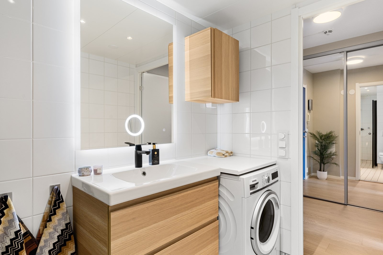 Badet er innredet med vegghengt toalett, servant med baderomsinnredning, speil og belysning, samt dusjhjørne med vegger/dører i herdet glass. Det er opplegg for vaskemaskin. Galleribilde