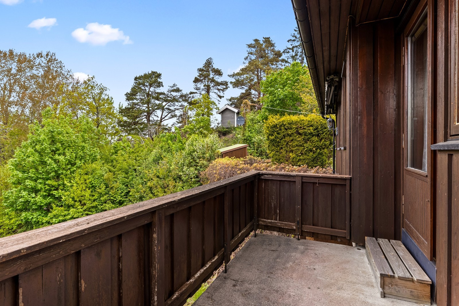 Denne verandaen er en betongkonstruksjon med trerekkverk. Galleribilde