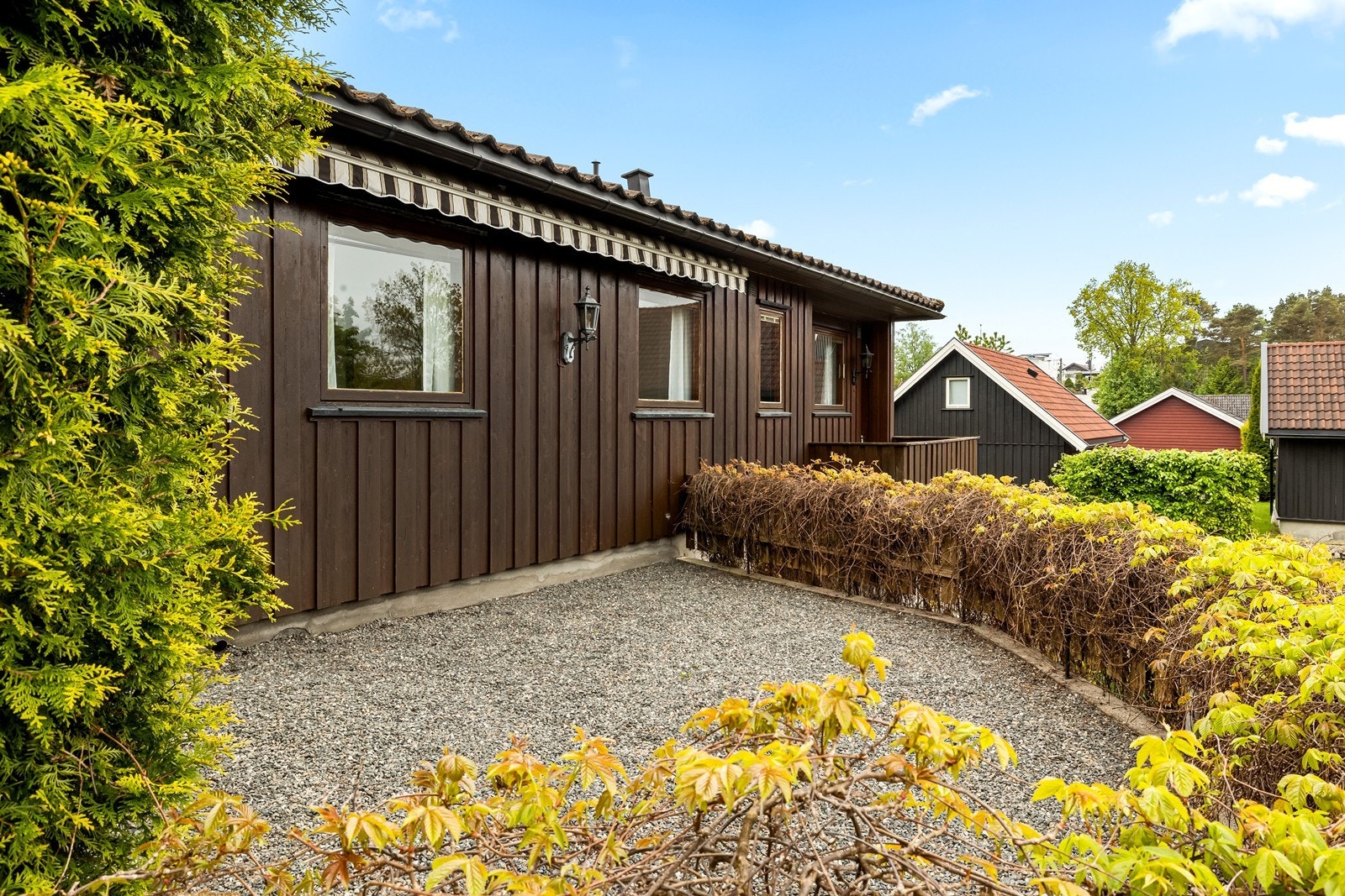 På siden av huset, mot vest er det også gruset uteplass med lavt rekkverk. Galleribilde