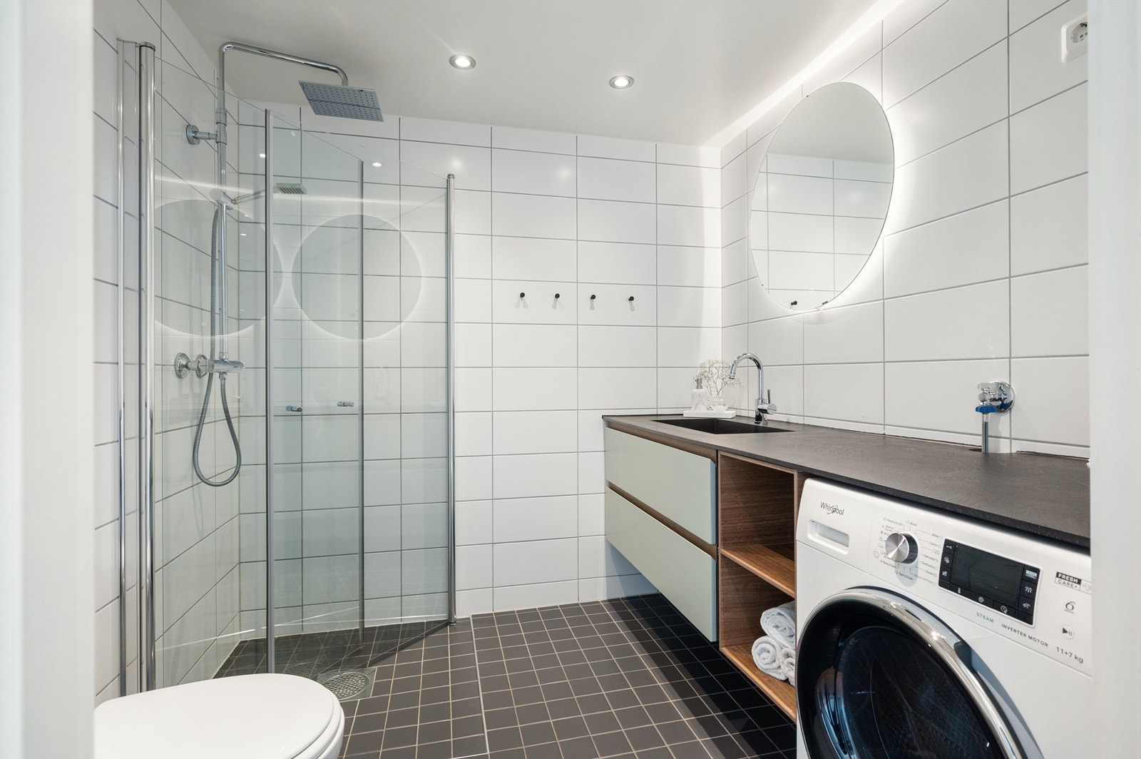 Delikat flislagt baderom med gulvvarme, downlights og opplegg for vaskemaskin Galleribilde