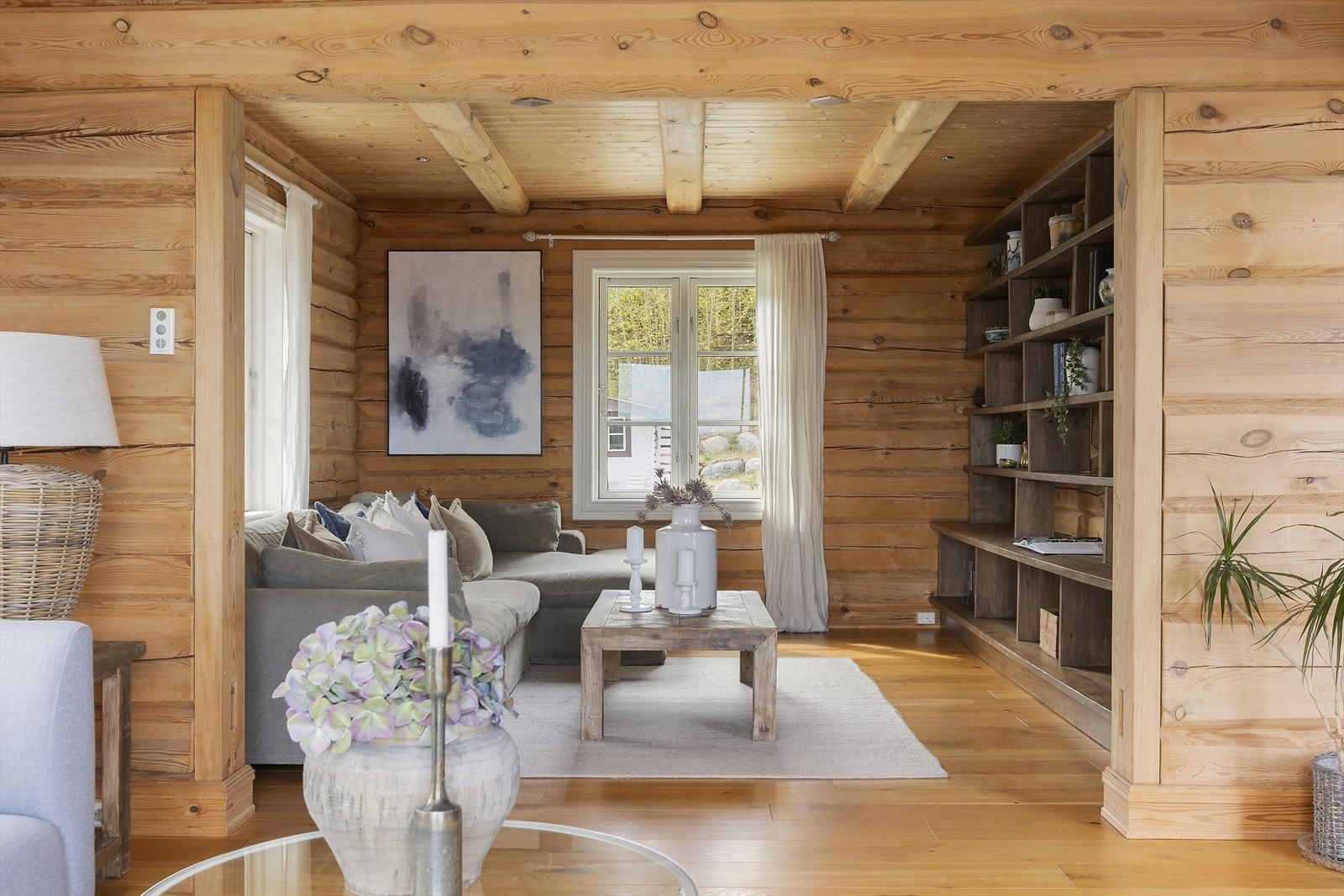 Stuen har god plass til sofagruppe og er preget av massive tømmervegger og panel i taket. Galleribilde