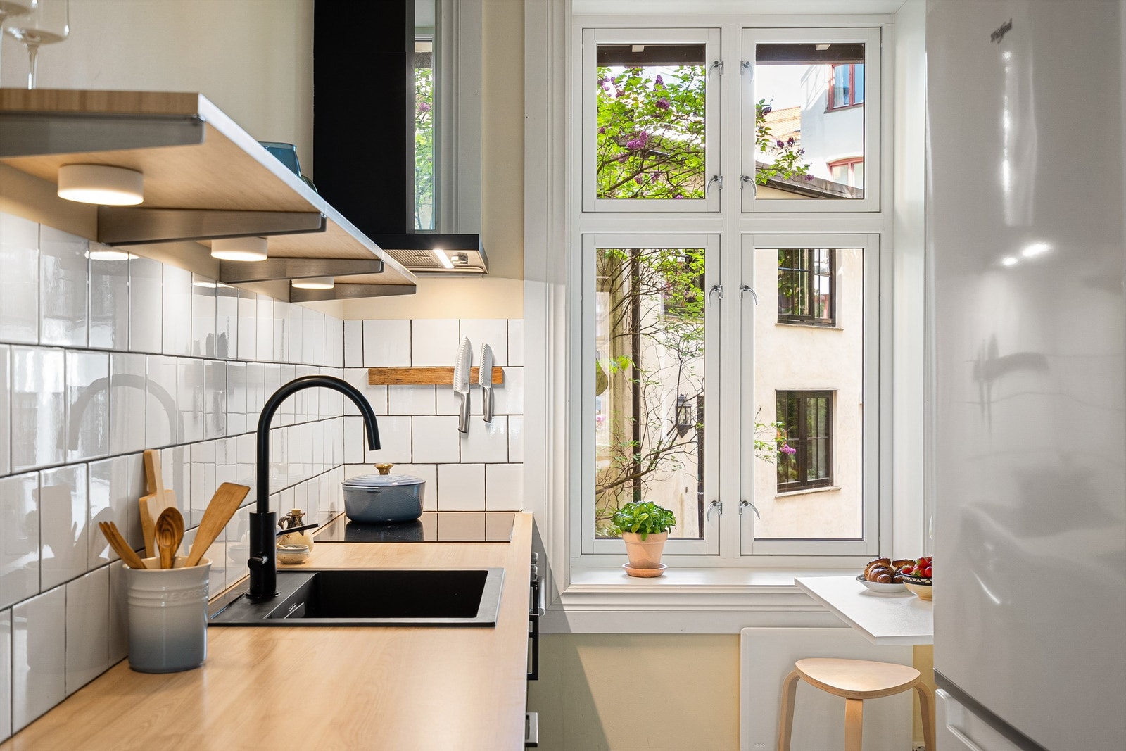 Kjøkkenet vender ut mot hyggelig bakgård og foran vinduet er det et lite utslagsbord - perfekt for frokost eller raske måltider. Galleribilde