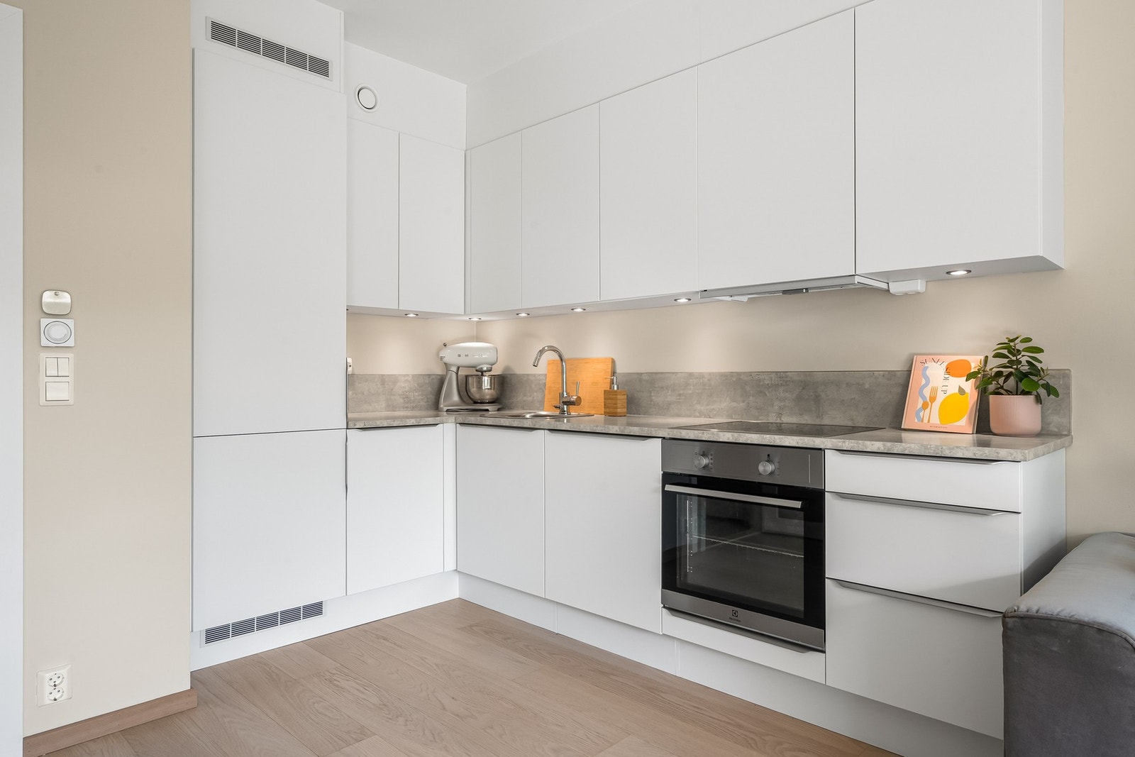 Innredningen har hvite glatte fronter og laminert benkeplate med nedfelt oppvaskkum. God belysning med innfelte downlights under overskapene. Galleribilde