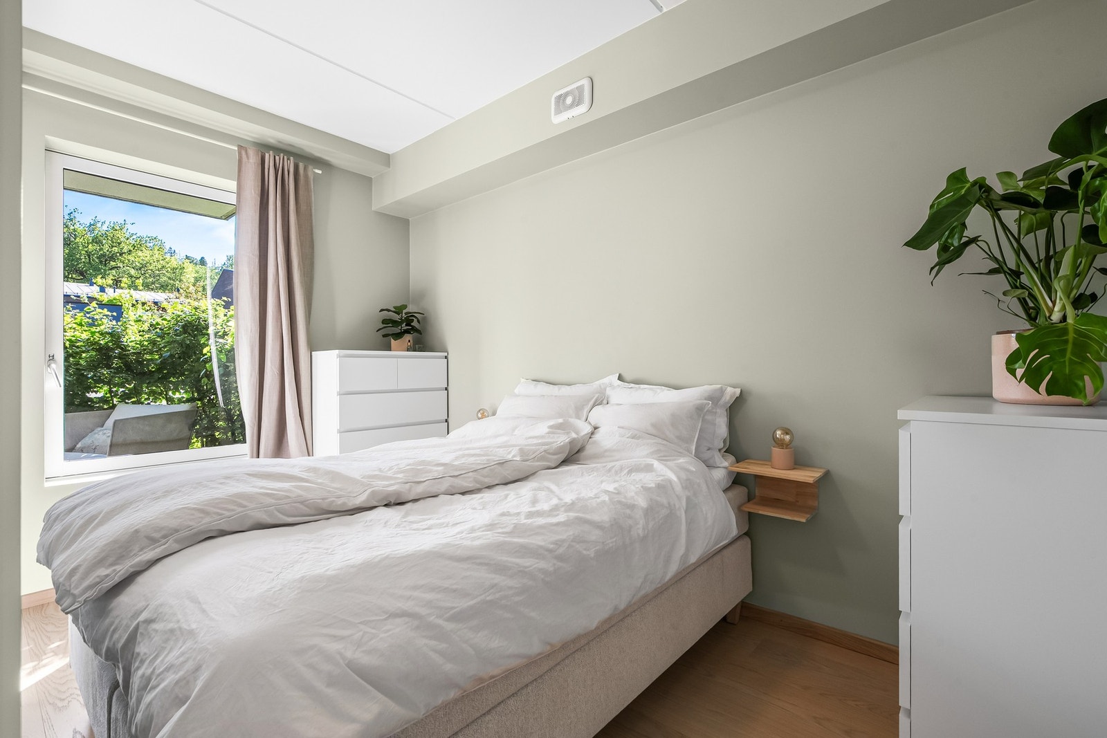 Leiligheten har et lyst og innbydende soverom med adkomst via skyvedører på hver side av sengen. Galleribilde