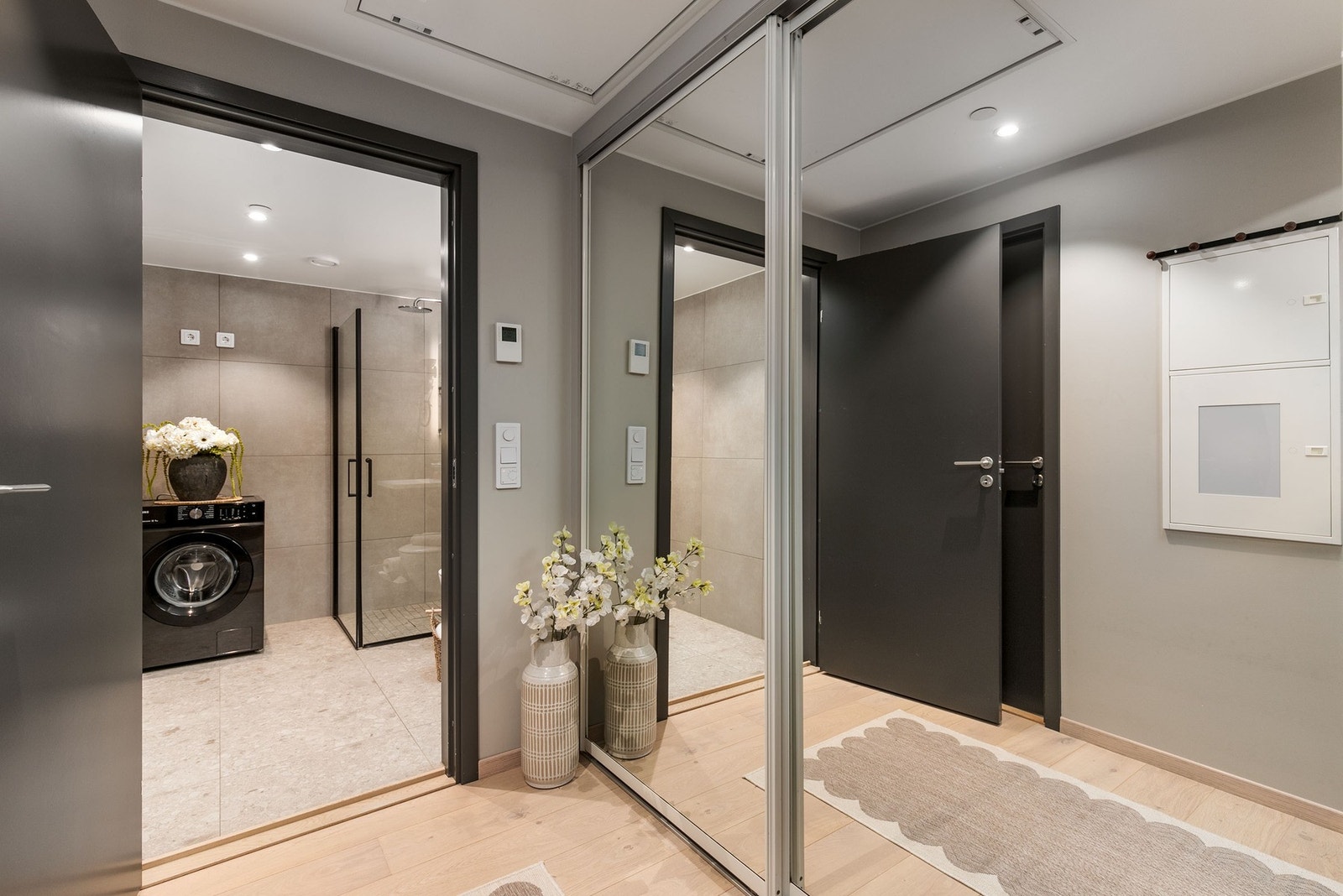 Badet har dusj med innfellbare dører i herdet glass, servant, vegghengt klosett med innebygget sisterne og opplegg for vaskemaskin. Galleribilde