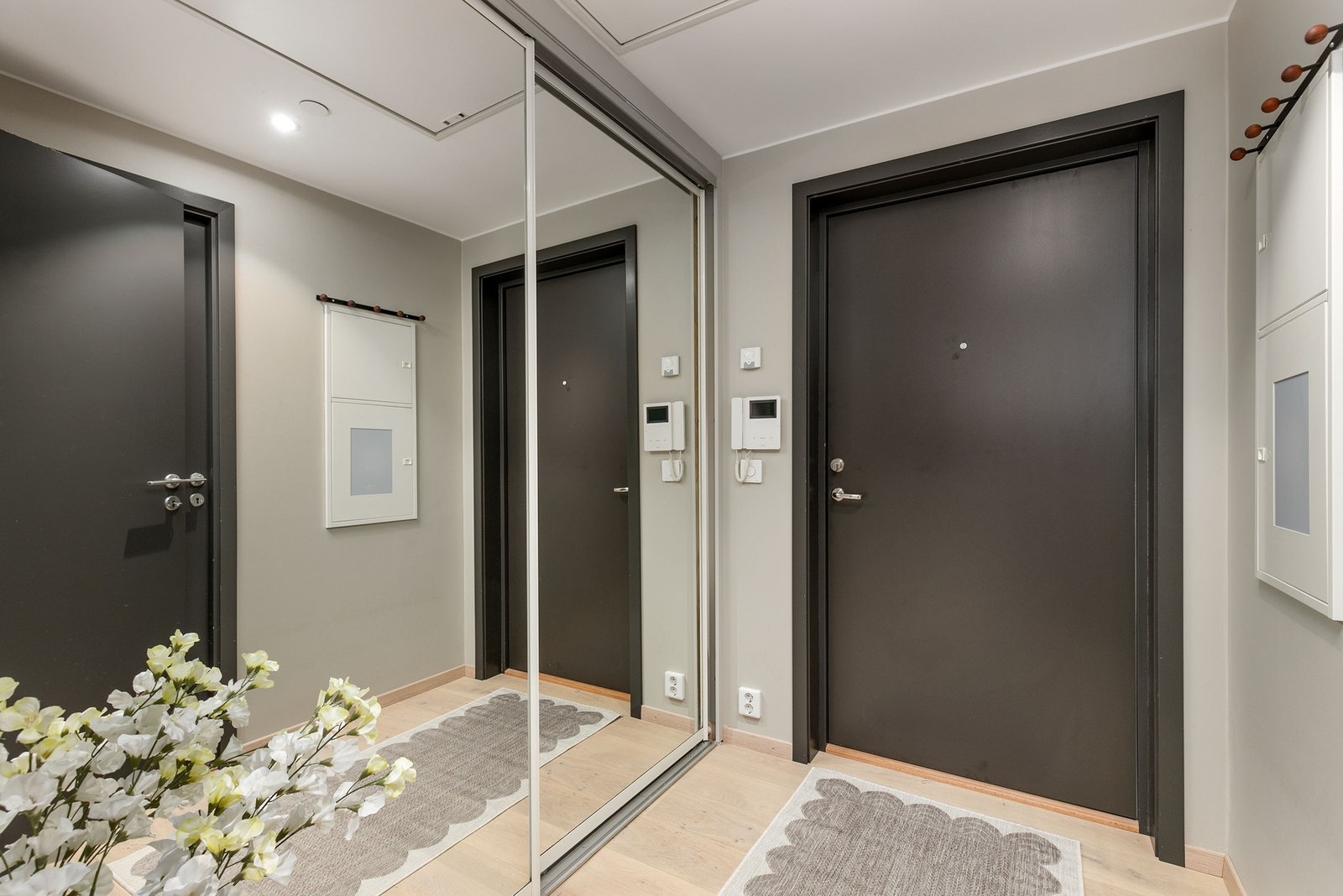 Entré med moderne overflater, downlights og garderobeløsning med speilfronter. Samt dørcalling. Galleribilde
