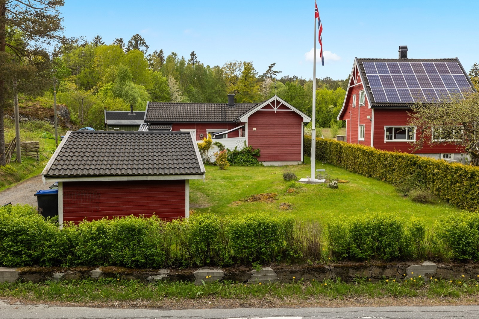 Tomten er opparbeidet med gressplen, hekk og diverse beplantning. Galleribilde